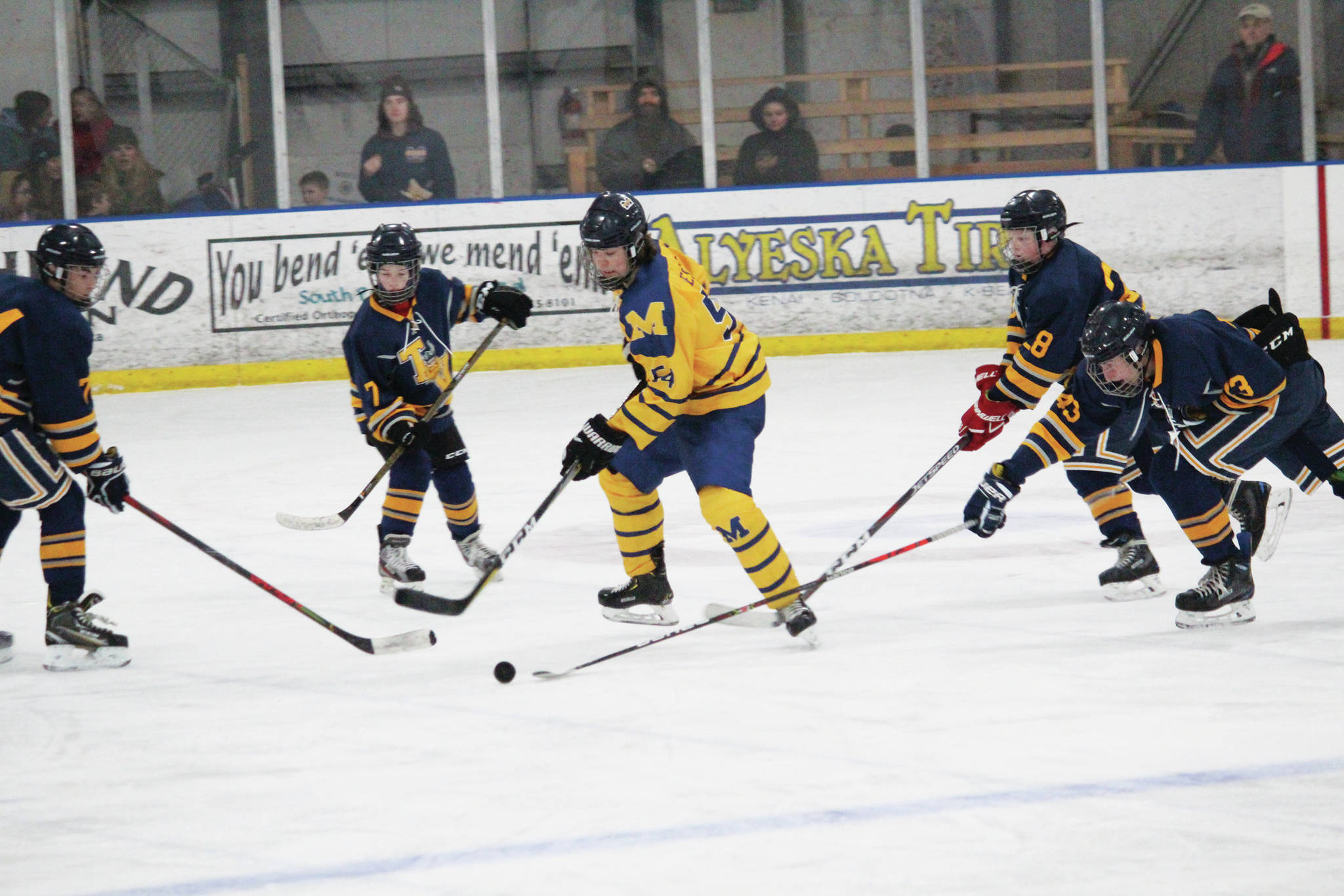 Homer’s Phinny Weston tries to control the puck among a group of Tri-Valley School players during a Thursday, Jan. 30, 2020 hockey game at the Kevin Bell Arena in Homer, Alaska. (Photo by Megan Pacer/Homer News)