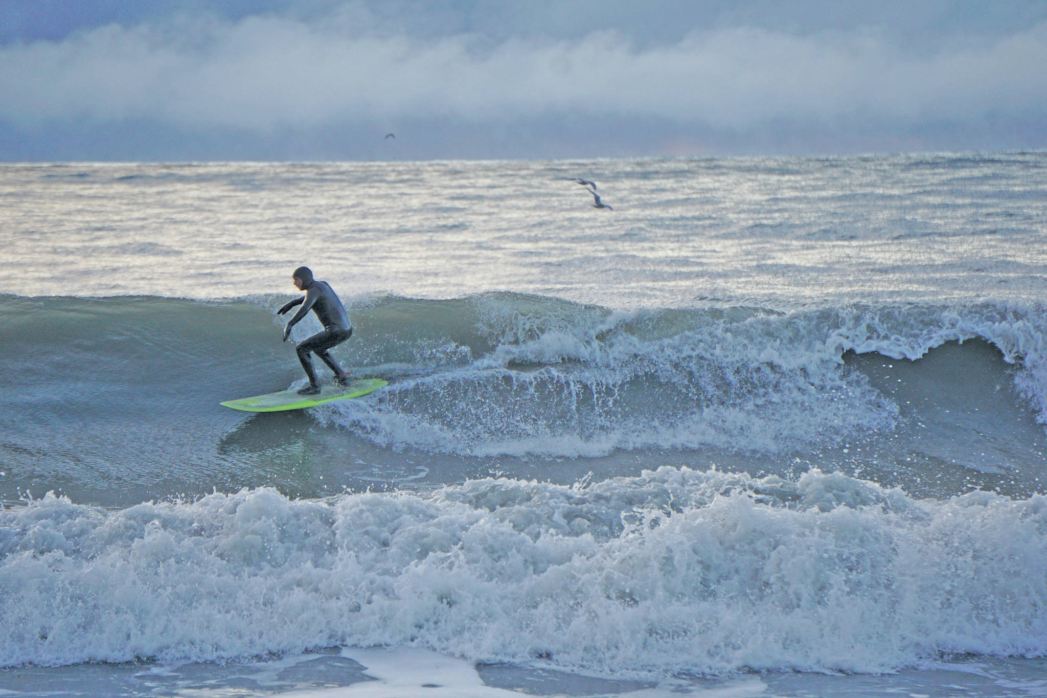 A man surfs off the Homer Spit on Thursday afternoon, Jan. 30 in Homer. (Photo by MIchael Armstrong/Homer News)