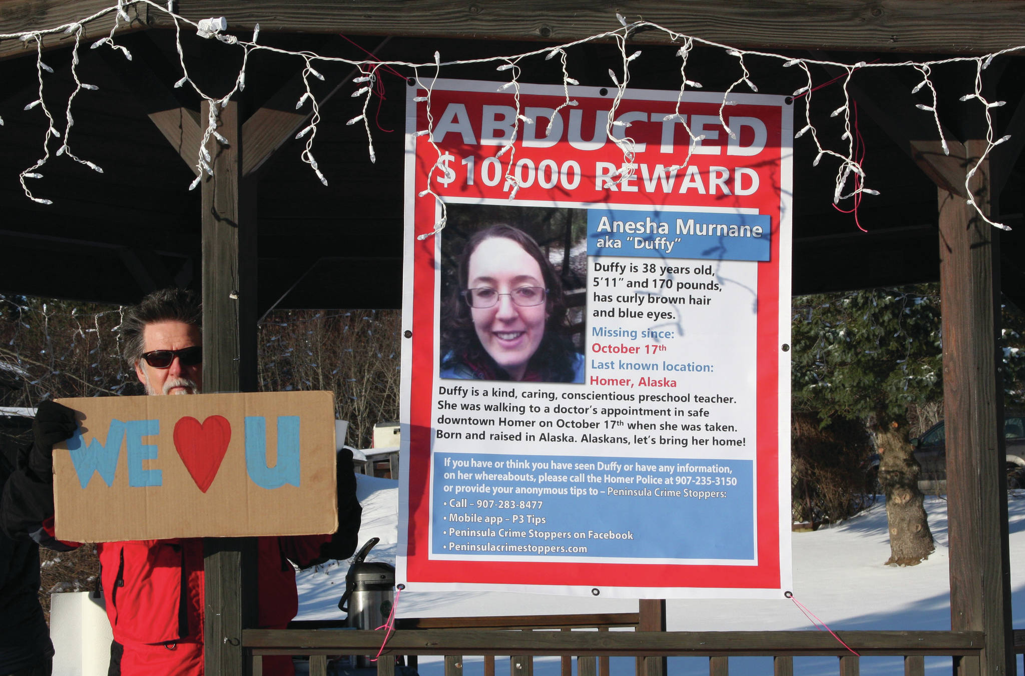 Wes Schacht, a friend and tenant of Sara and Ed Berg, stands next to a “missing” poster of Anesha “Duffy” Murnane in the gazebo at WKFL Park during a candlelight vigil in Homer, Alaska, on Saturday, Feb. 1, 2020. (Photo by Delcenia Cosman)