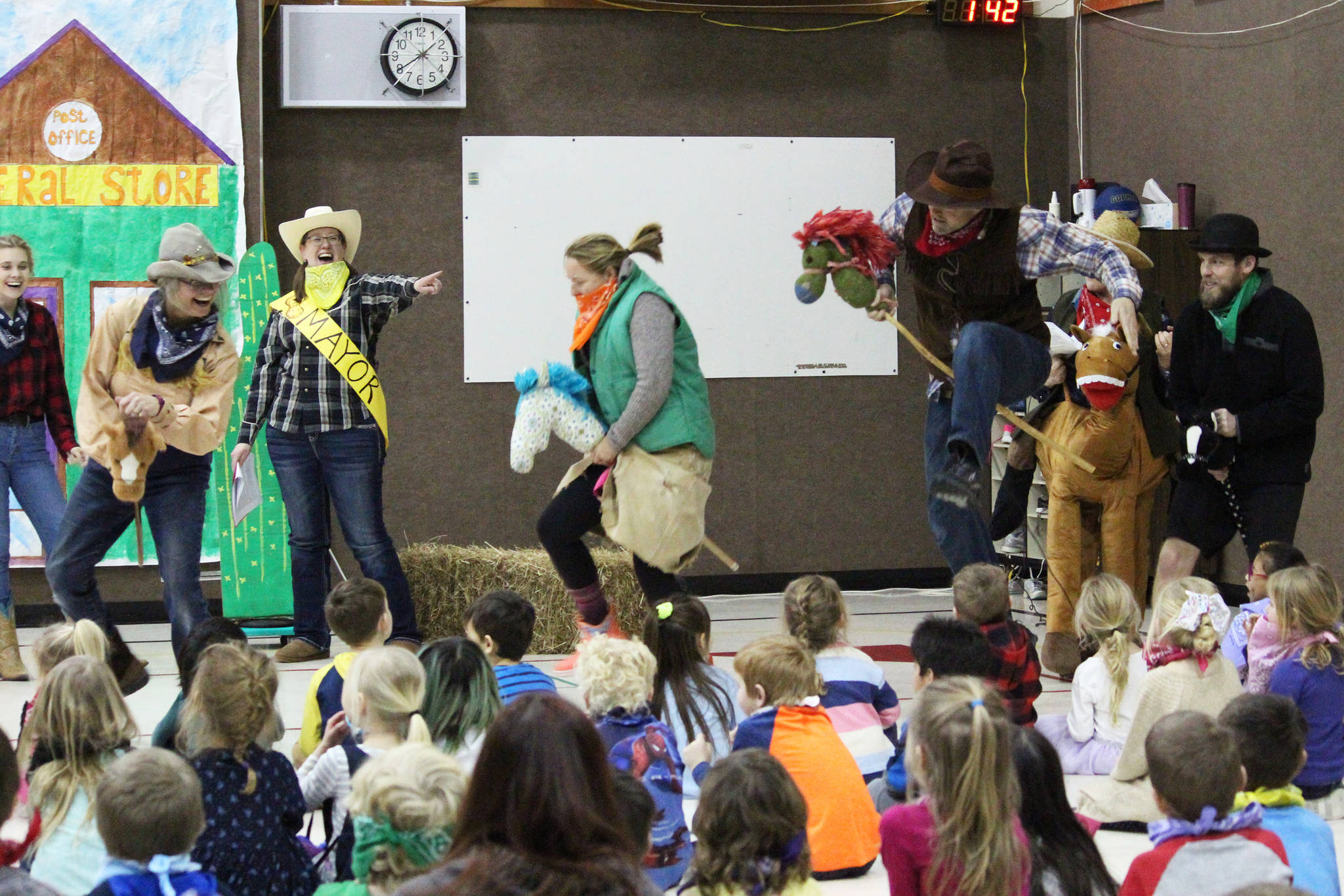 A group of teachers rush into the gym at Paul Banks Elementary School pretending to be a posse chasing down bandits during an assembly celebrating the start of the annual Read-A-Thon on Feb. 3, 2020 at the school in Homer, Alaska. The theme of this year’s celebratory skit was the wild west. (Photo by Megan Pacer/Homer News)