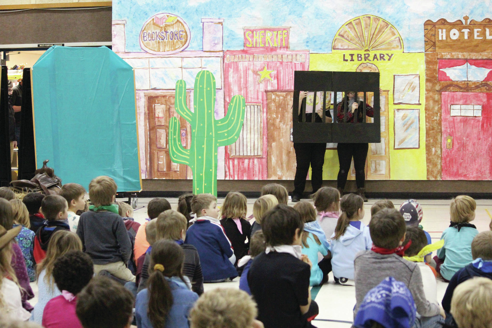 Students at Paul Banks Elementary School listen to an assembly celebrating the kickoff of the school’s annual Read-A-Thon on Feb. 3, 2020 at the school in Homer, Alaska. Each year’s celebration has a different theme, and this year the teachers and staff put on a wild west-themed skit. (Photo by Megan Pacer/Homer News)