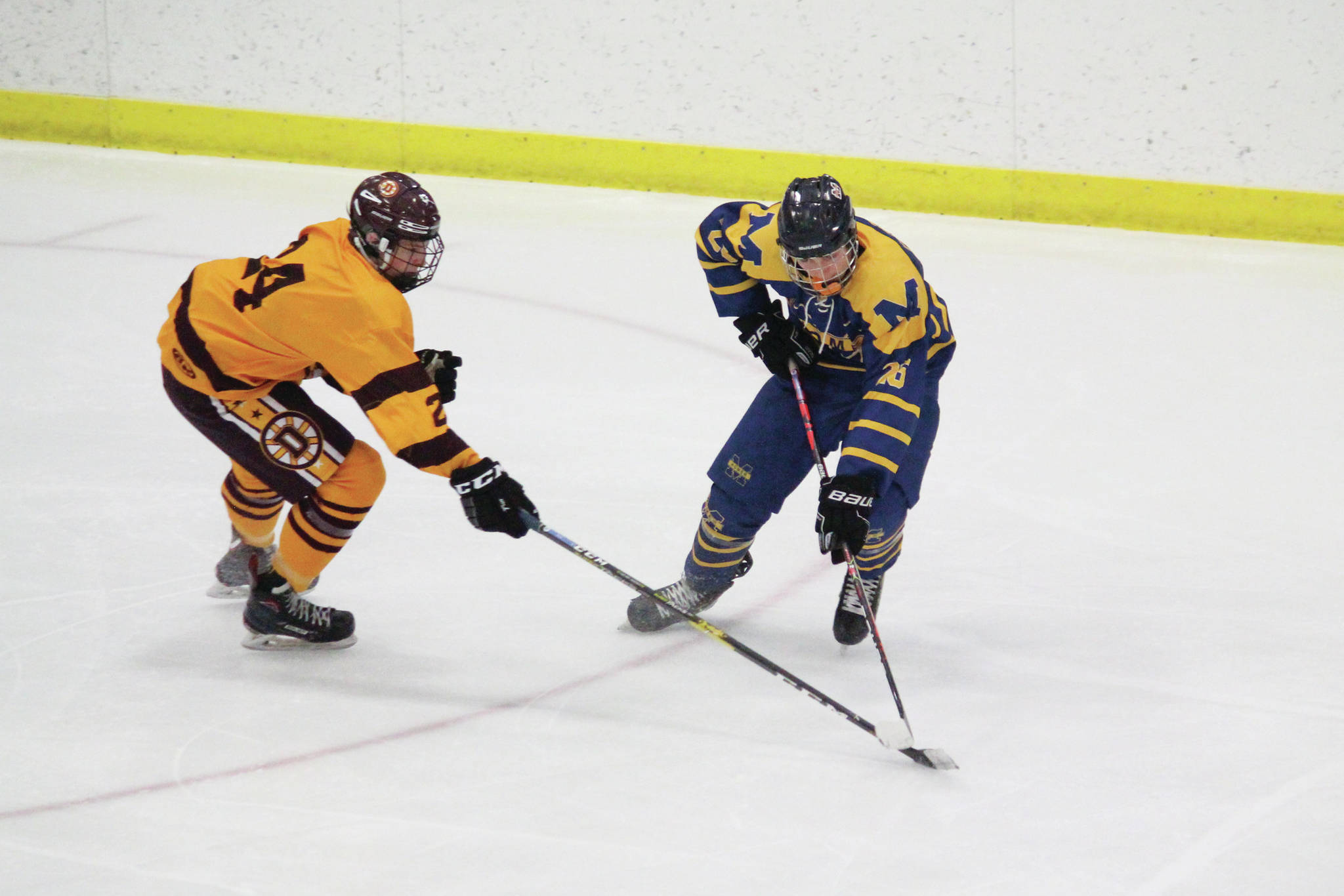 Homer’s Ethan Pitzman and Dimond’s Drake Reid connect over the puck during a Friday, Feb. 14, 2020 game in the 2020 ASAA First National Cup Division I Hockey State Championship at the Curtis D. Menard Memorial Sports Center in Wasilla, Alaska. (Photo by Megan Pacer/Homer News)