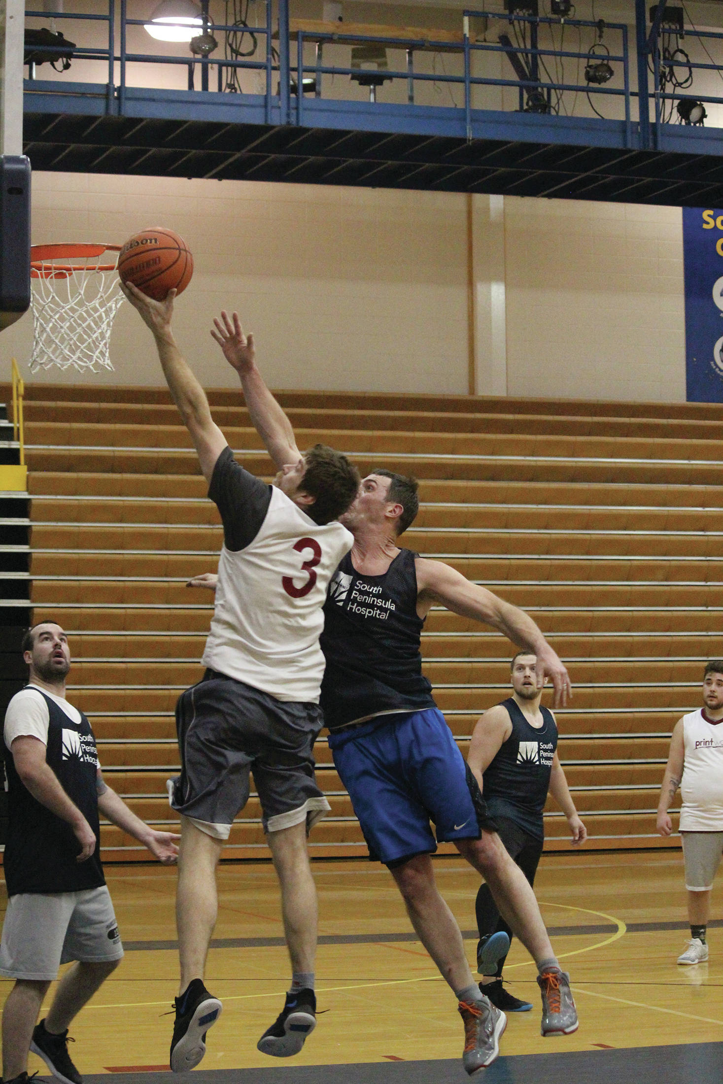 Gavin Keohane (No. 3) jumps to make a shot while Dan Miotke follows during the championship game of the Homer Community Recreation Department’s Adult Basketball League Playoffs on Monday, Feb. 17, 2020 at Homer High School in Homer, Alaska. (Photo by Megan Pacer/Homer News)