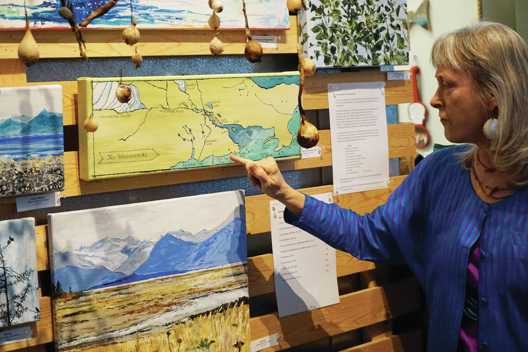 Deborah Poore discusses one of her paintings at the Friday, Feb. 7, 2020, opening of her show, “Many Moods of the Wosnesenski” at Grace Ridge Brewery in Homer, Alaska. (Photo by Michael Armstrong/Homer News)