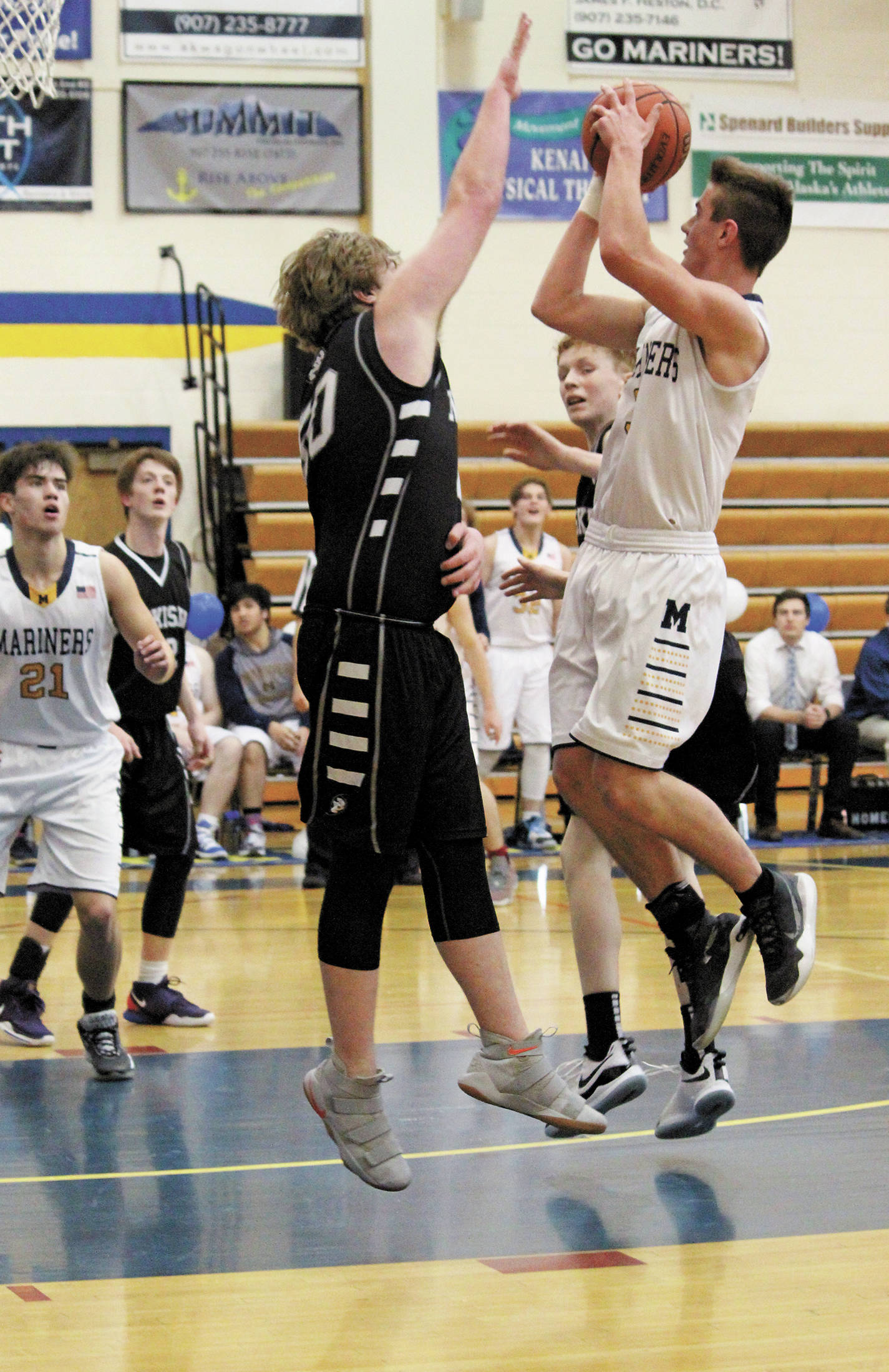 Homer’s Clayton Beachy jumps to take a shot while Nikiski’s Drew Handley reaching to block him during a Friday, Feb. 28, 2020 basketball game in the Alice Witte Gymnasium in Homer, Alaska. (Photo by Megan Pacer/Homer News)