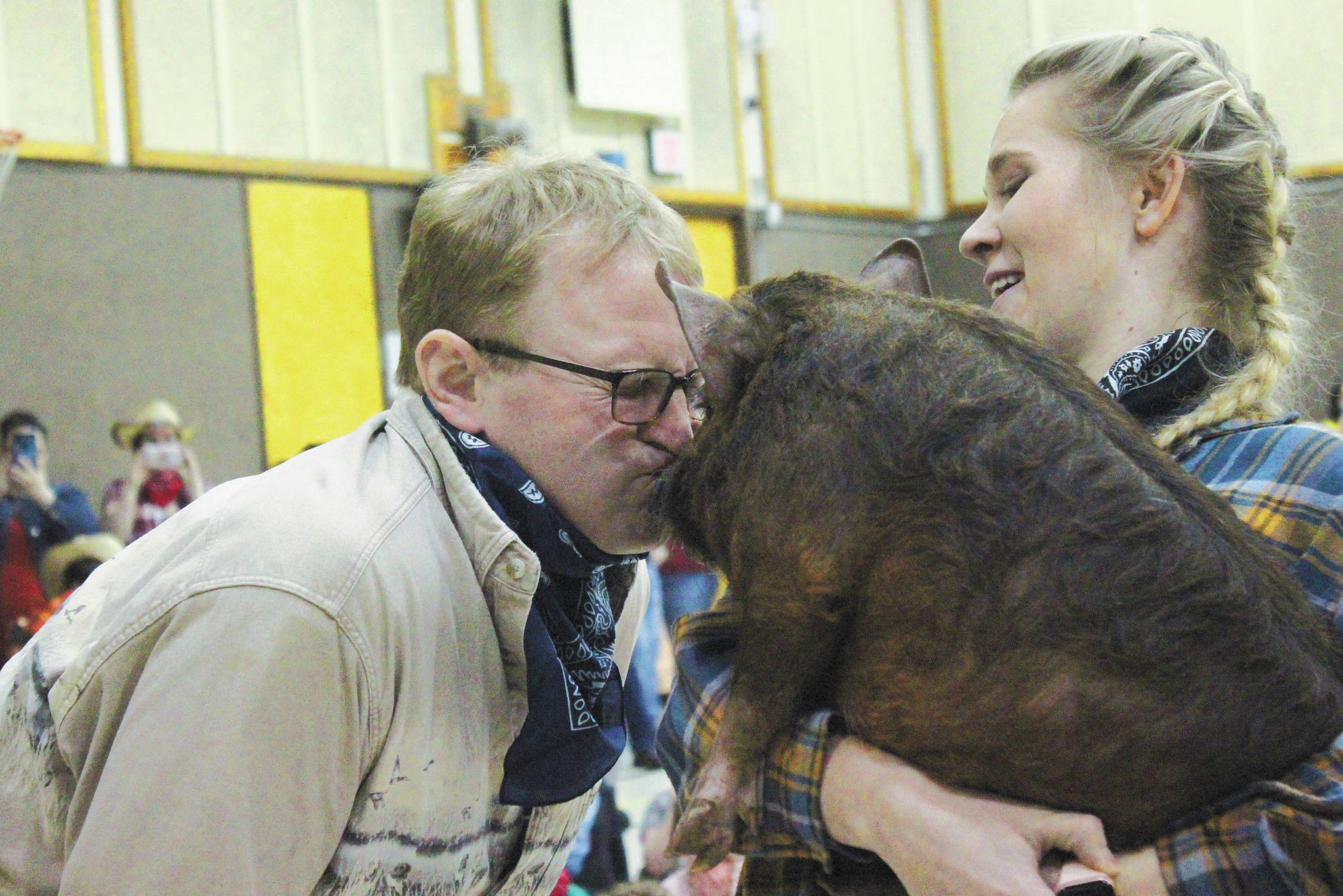 Paul Banks Elementary School Principal Eric Pederson kisses a pig during a Thursday, March 5, 2020 wild west-themed assembly to celebrate the end of the school’s annual read-a-thon, at the school in Homer, Alaska. During the kickoff assembly for the read-a-thon, Pederson had promised his students to kiss the pig if they were able read for a collective 150,000 minutes. (Photo by Megan Pacer/Homer News)
