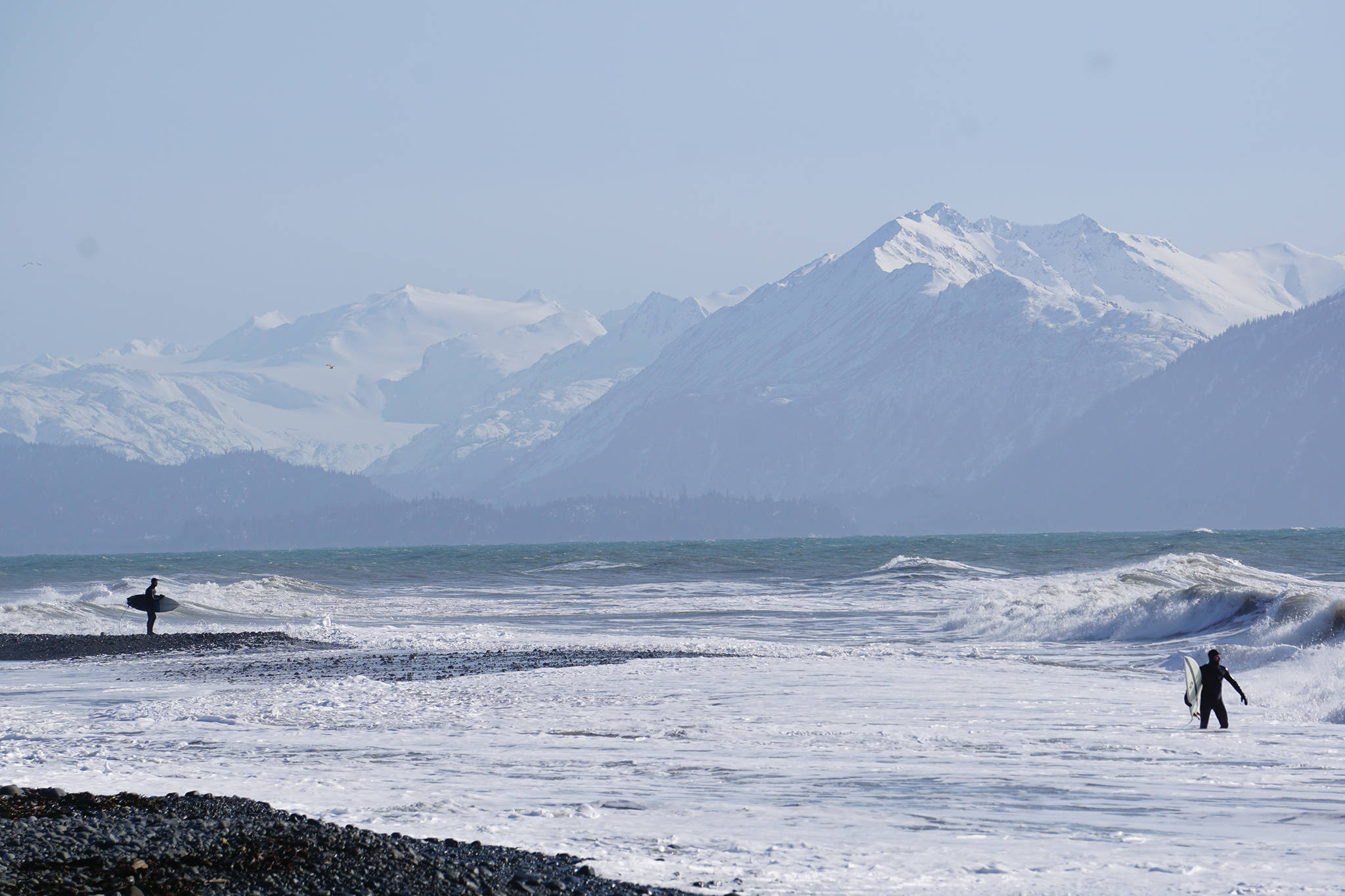 Two surfers watch for good waves at Bishop’s Beach on Sunday, March 22, 2020, in Homer, Alaska. (Photo by Michael Armstrong/Homer News)