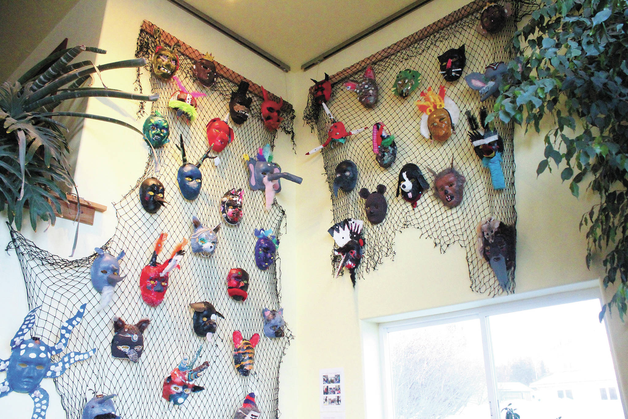 Decorative masks made by Fireweed Academy students hang in K-Bay Caffe during an art exhibit opening on Thursday, March 5, 2020 in Homer, Alaska. The masks were made with the help of Artist in the Schools Program participant Gail Baker. (Photo by Megan Pacer/Homer News)