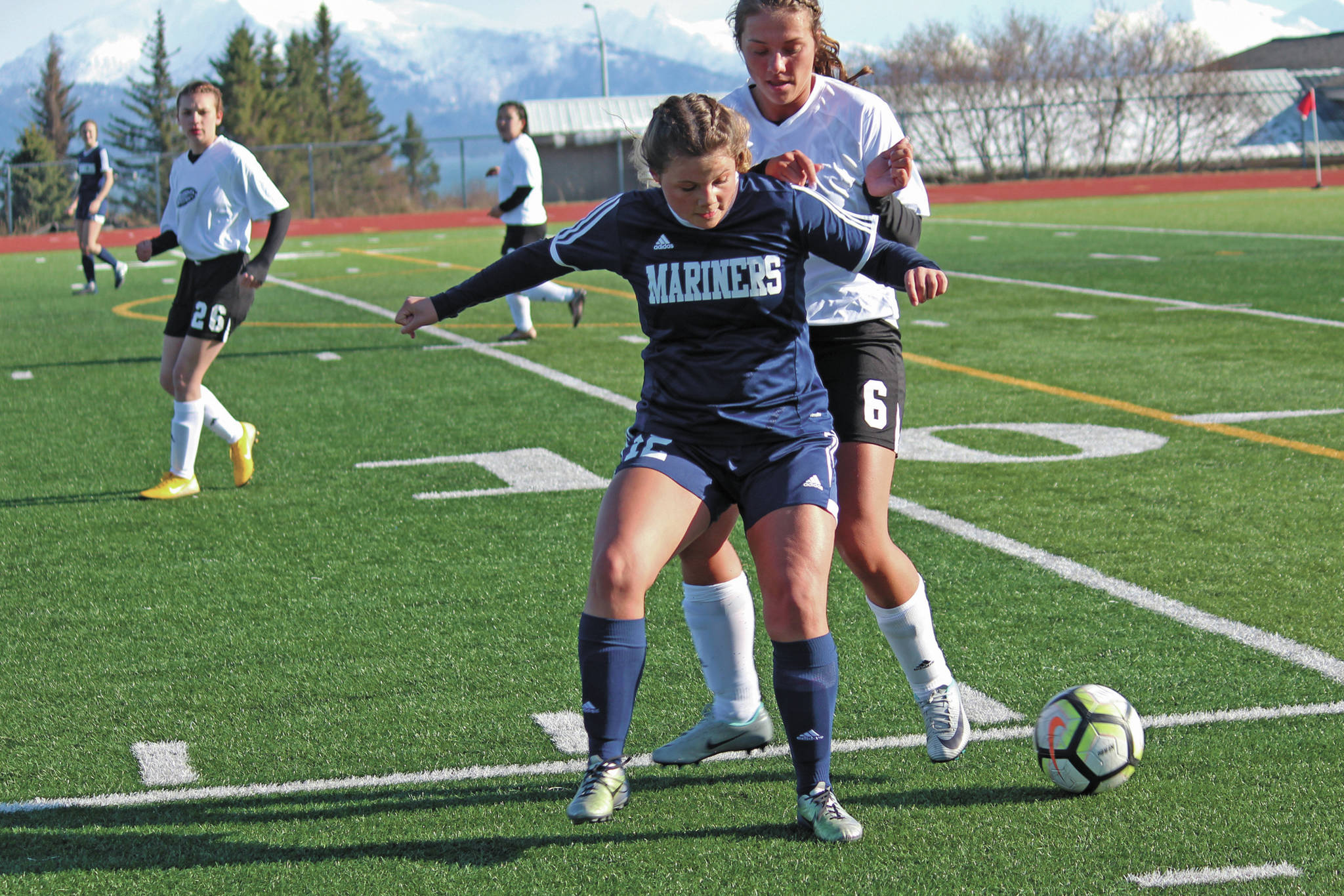 Homer’s Rylee Doughty gets in front of Nikiski’s Emma Wik while battling for the ball during an April 23, 2019 game at Homer High School in Homer, Alaska. (Photo by Megan Pacer/Homer News)