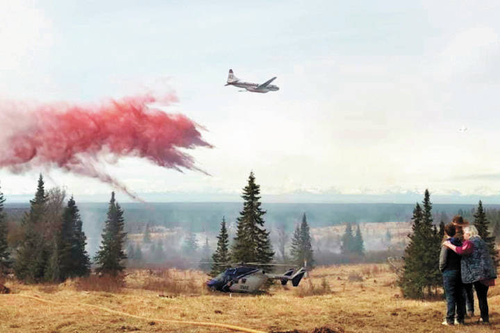 Fire retardant is dropped from a Convair 580 air tanker contracted by the State Division of Forestry from Conair Group, Inc. of Abbottsford, British Columbia, onto a wildland fire Sunday, May 10, 2020 near Ninilchik, Alaska. This was the first retardant drop of the fire season for the Division of Forestry. (Photo by Chris Scudder)