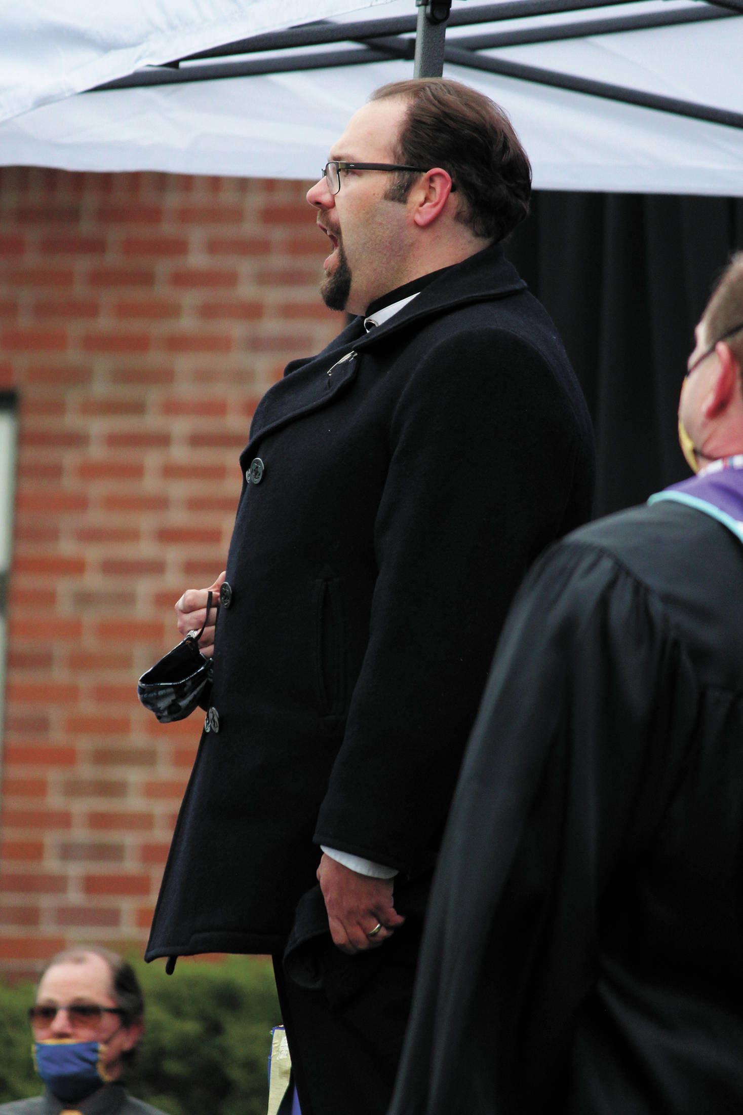 Kyle Schneider, director of choirs for Homer High School and Homer Middle School, sings the national anthem at Homer High School’s Monday, May 18, 2020 graduation ceremony at the school in Homer, Alaska. (Photo by Megan Pacer/Homer News)