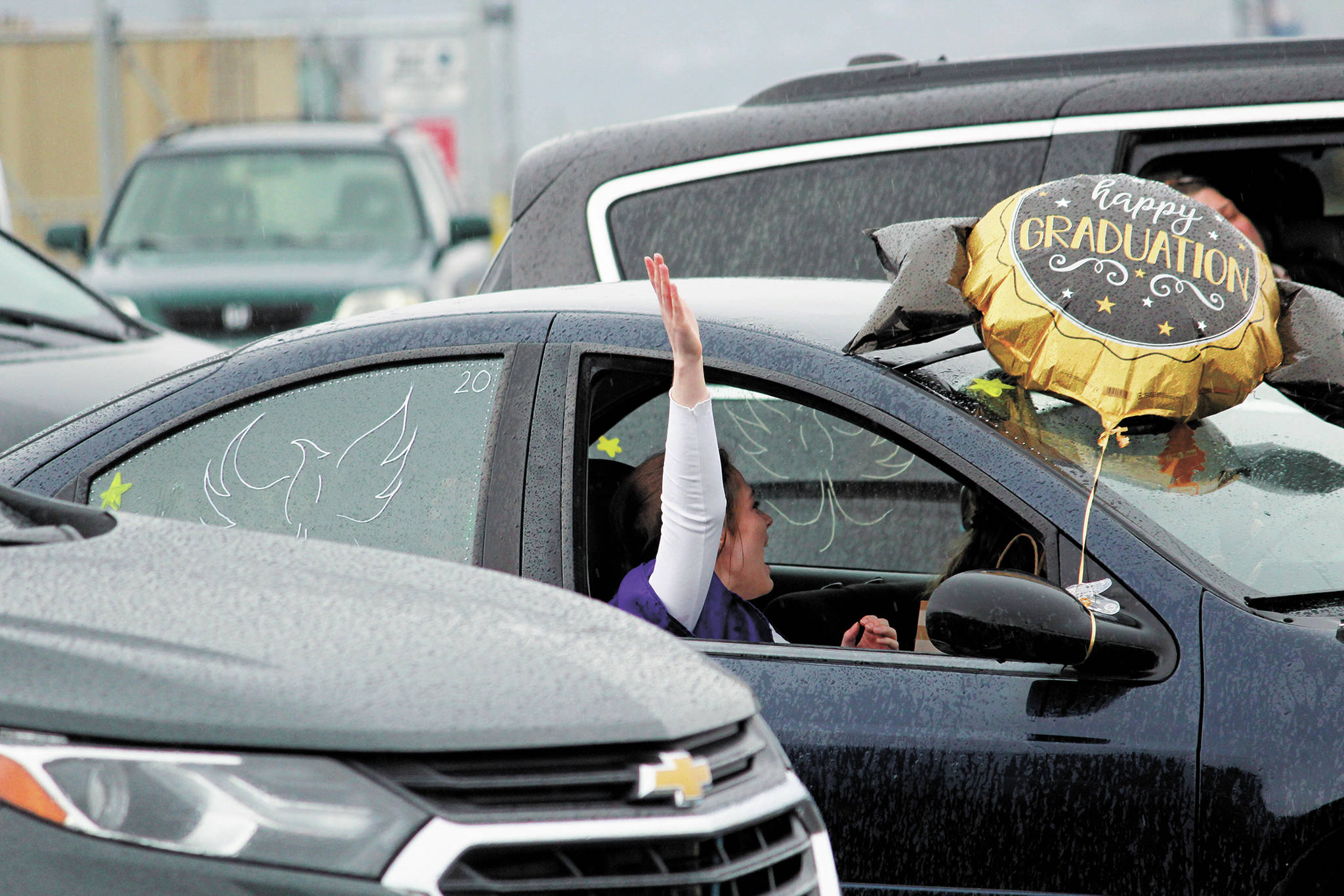 Graduate Audnia Carlson celebrates out her car window during a Monday, May 18, 2020 commencement ceremony for Homer Flex School at the Homer Harbor in Homer, Alaska. (Photo by Megan Pacer/Homer News)