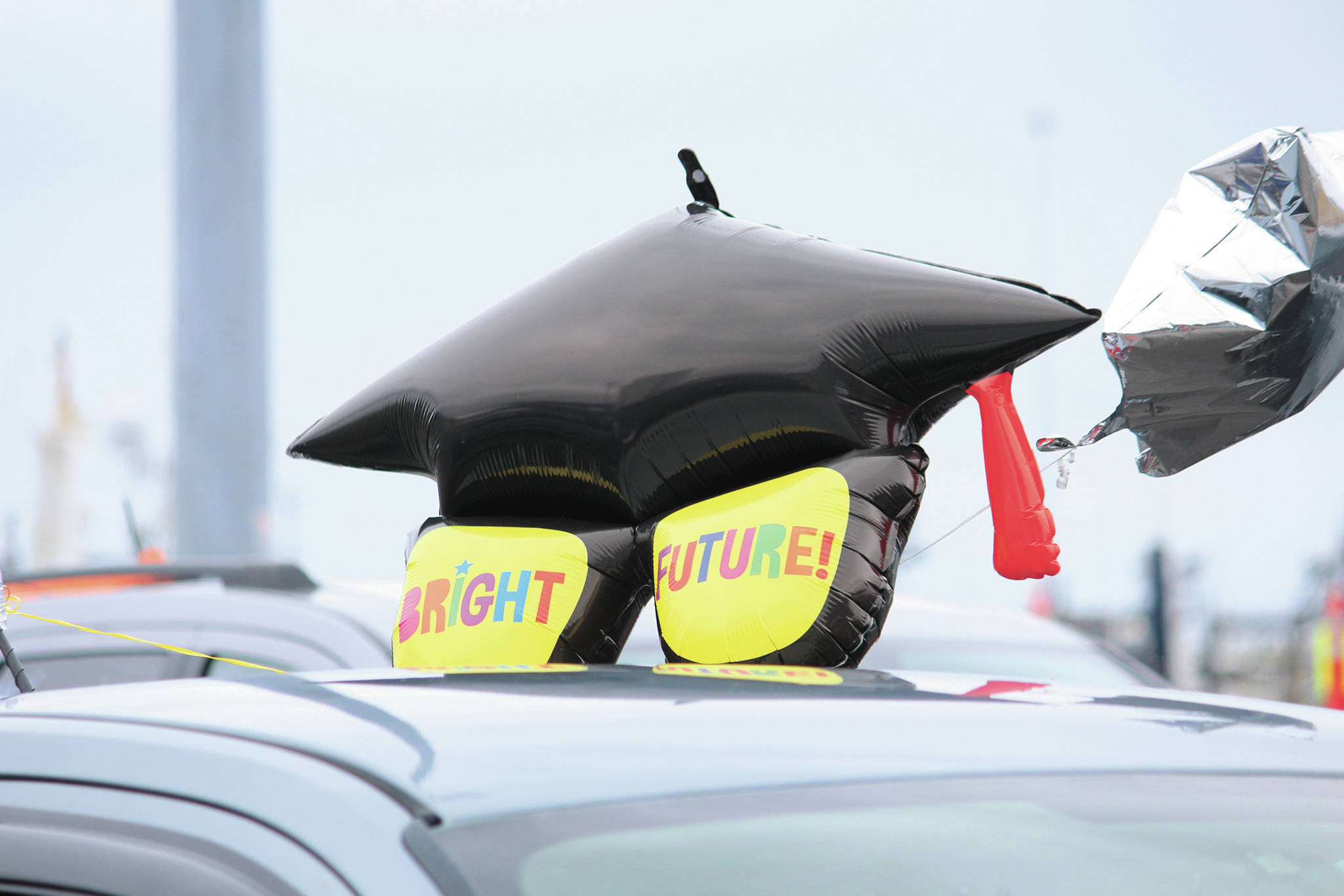 A graduation balloon sits atop a vehicle during an alternative graduation ceremony for Homer Flex School on Monday, May 18, 2020 at the Homer Harbor in Homer, Alaska. (Photo by Megan Pacer/Homer News)