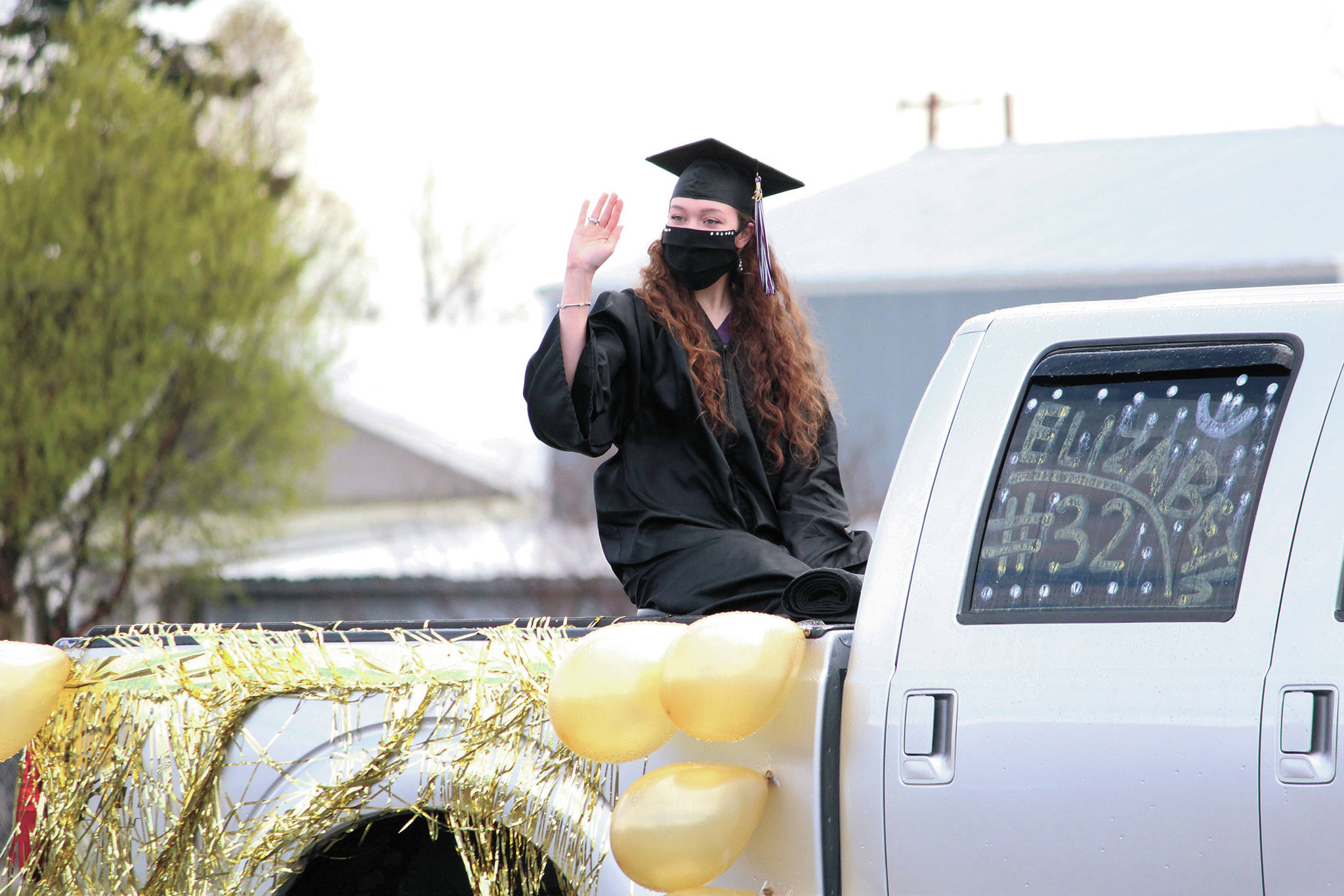 Nikolaevsk School graduate Elizabeth Fefelov waves as her family leaves the drive-in commencement celebration the school held Tuesday, May 19, 2020 in Nikolaevsk, Alaska. (Photo by Megan Pacer/Homer News)