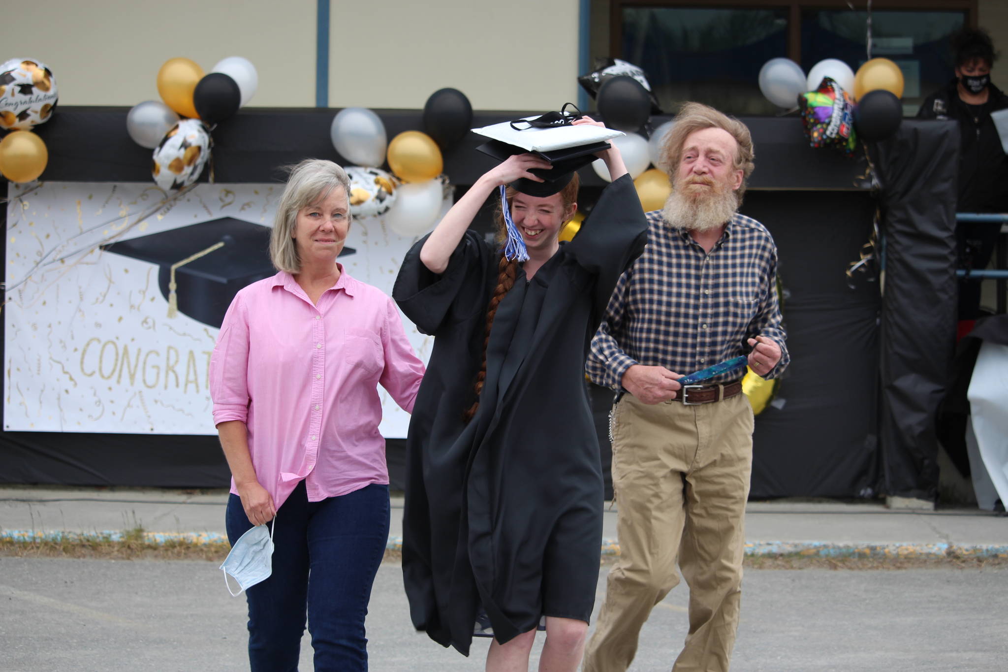 Graduate Virginia Orth walks back to her car with her parents, April and David Orth, after receiving her diploma during the Connections Homeschool Class of 2020 graduation at Soldotna Elementary School in Soldotna, Alaska on May 21, 2020. (Photo by Brian Mazurek/Peninsula Clarion)