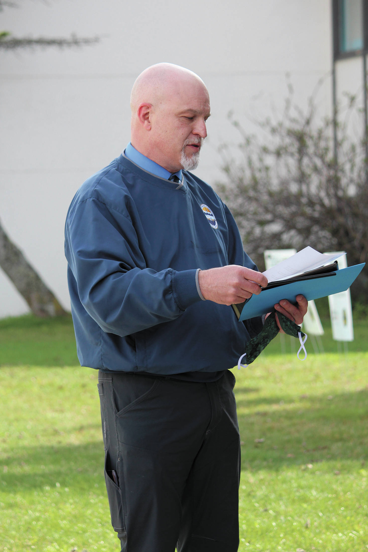 Ninilchik School Principal Jeff Ambrosier reads the scholarships graduates received during an alternative graduation ceremony outside the school Wednesday, May 20, 2020 in Ninilchik, Alaska. (Photo by Megan Pacer/Homer News)
