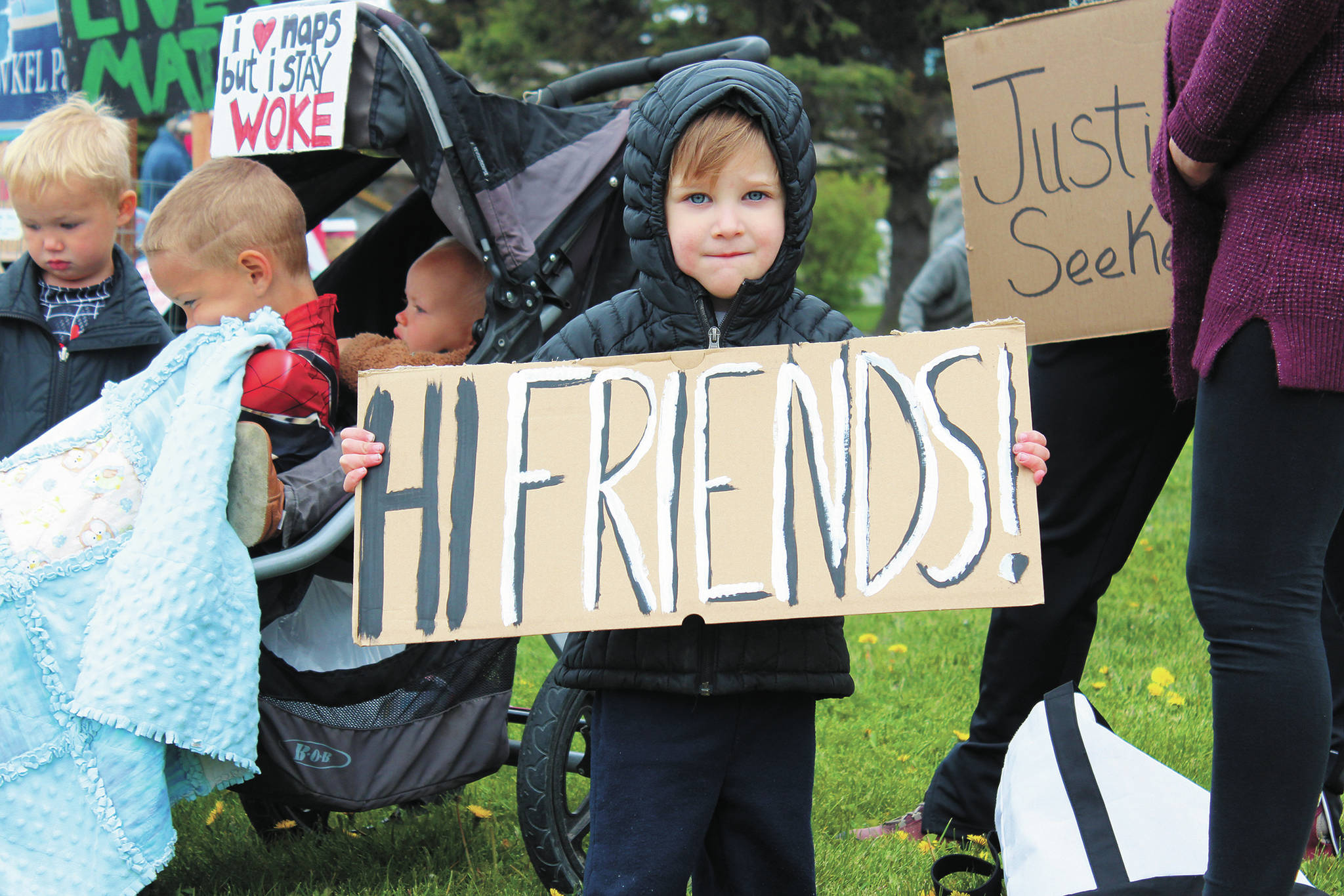 Remmik Toews, 2, holds up a sign that says “Hi friends!” during a Black Lives Matter demonstration on Tuesday, May 2, 2020 at WKFL Park in Homer, Alaska. (Photo by Megan Pacer/Homer News)
