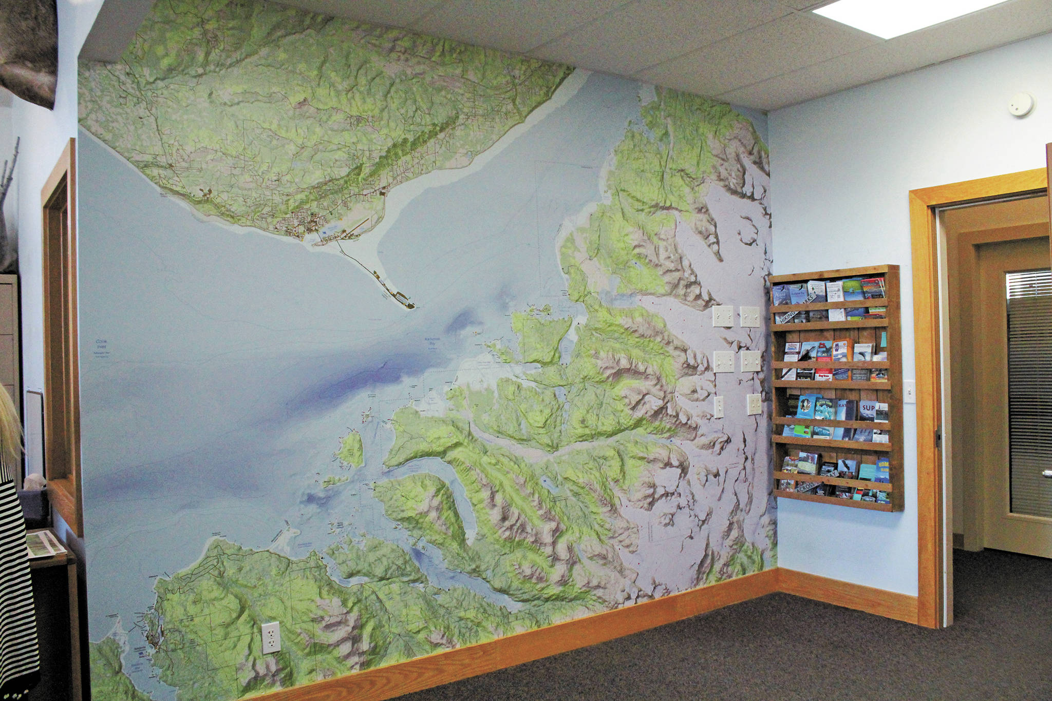 A detailed map of Kachemak Bay State Park, designed by Brentwood Higman, adorns the wall of the Homer Chamber of Commerce & Visitor Center during a celebration of the park’s 50th anniversary Saturday, June 6, 2020 in Homer, Alaska. (Photo by Megan Pacer/Homer News)