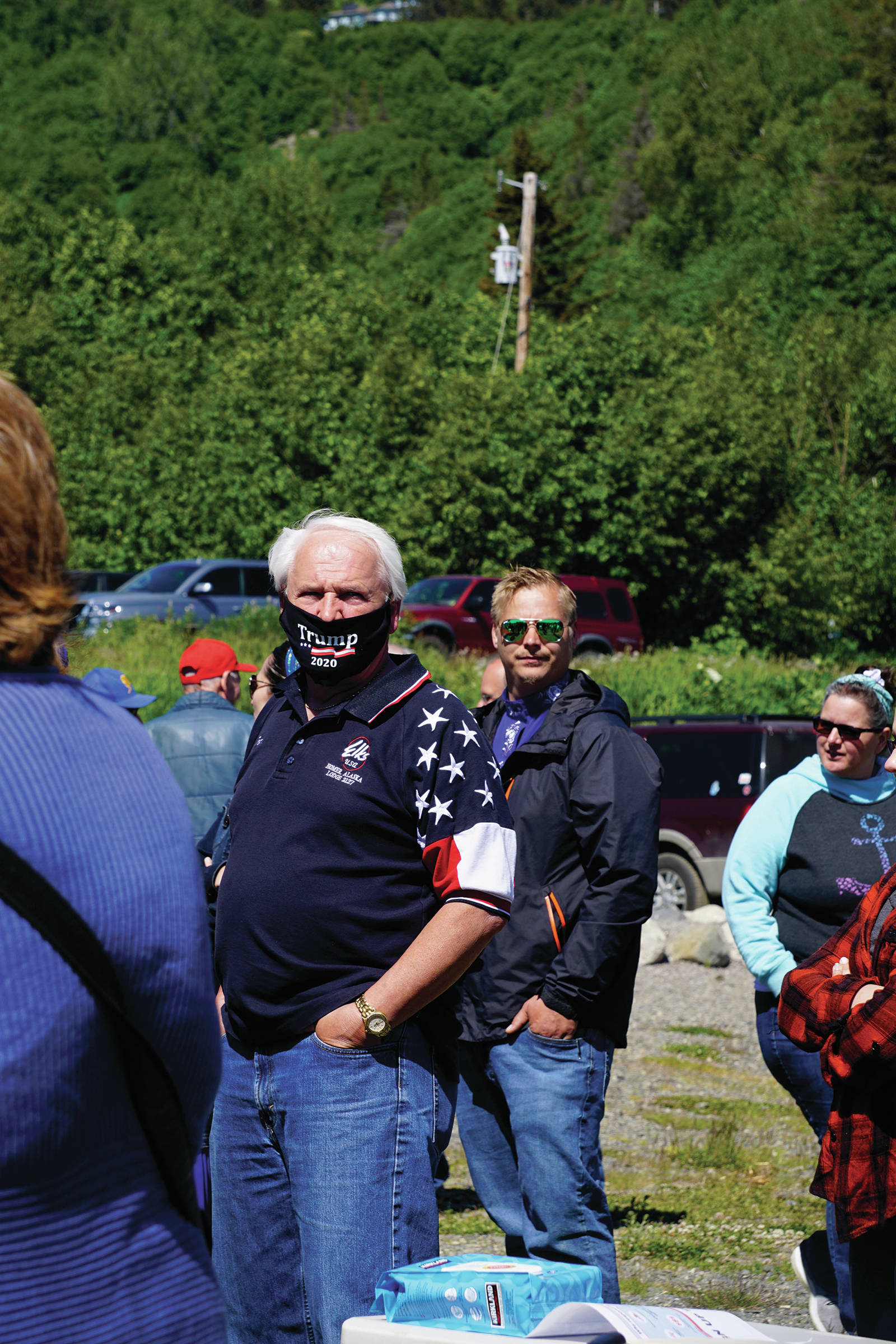 A man wearing a Trump 2020 face mask listens to Rep. Sarah Vance, R-Homer, at a kickoff for her re-election campaign on Sunday, June 14, 2020, at Karen Hornaday Park in Homer, Alaska. (Photo by Michael Armstrong/Homer News)