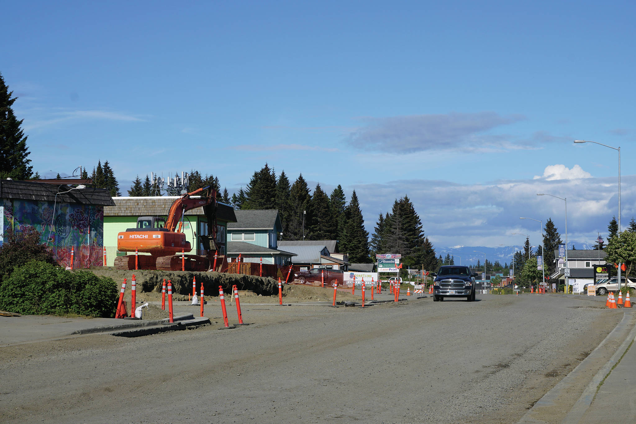 A driver heads west on Pioneer Avenue at Svedlund Street on Monday, June 22, 2020, in Homer, Alaska. A retaining wall at the intersection in front of the Pioneer Car Wash was moved back and a utility pole removed to create a better sight line at the corner, part of a repaving project for Pioneer Avenue. (Photo by Michael Armstrong/Homer News)