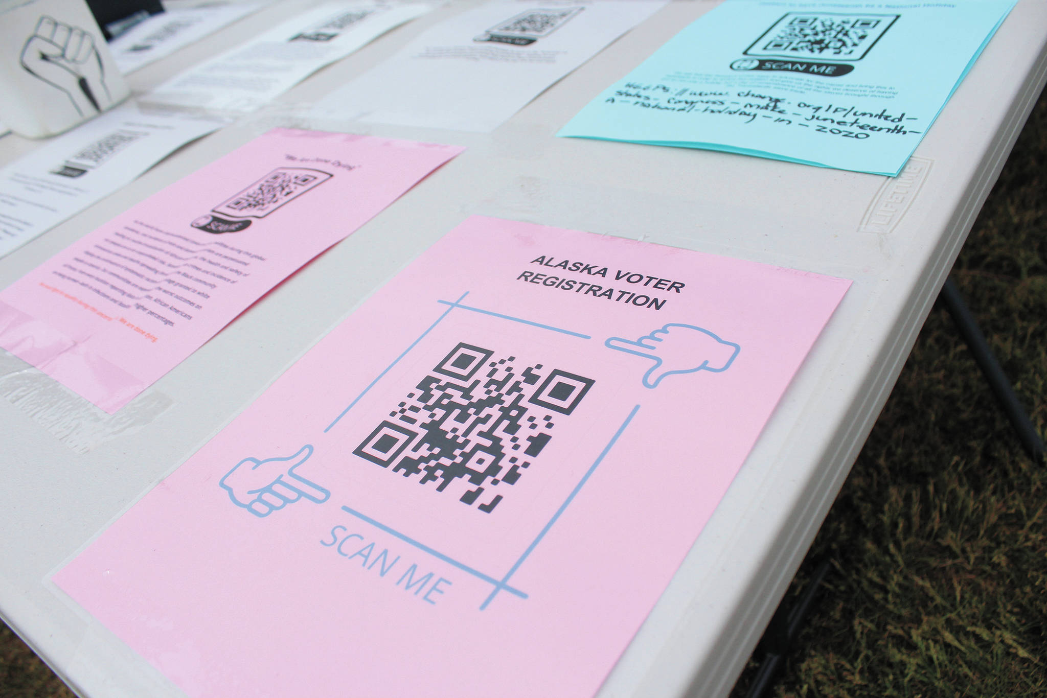 Several educational documents and donation resources, including a QR code to become a registered Alaska voter, rest on an education table at Homer’s first Juneteenth celebration Friday, June 19, 2020 at WKFL Park in Homer, Alaska. (Photo by Megan Pacer/Homer News)