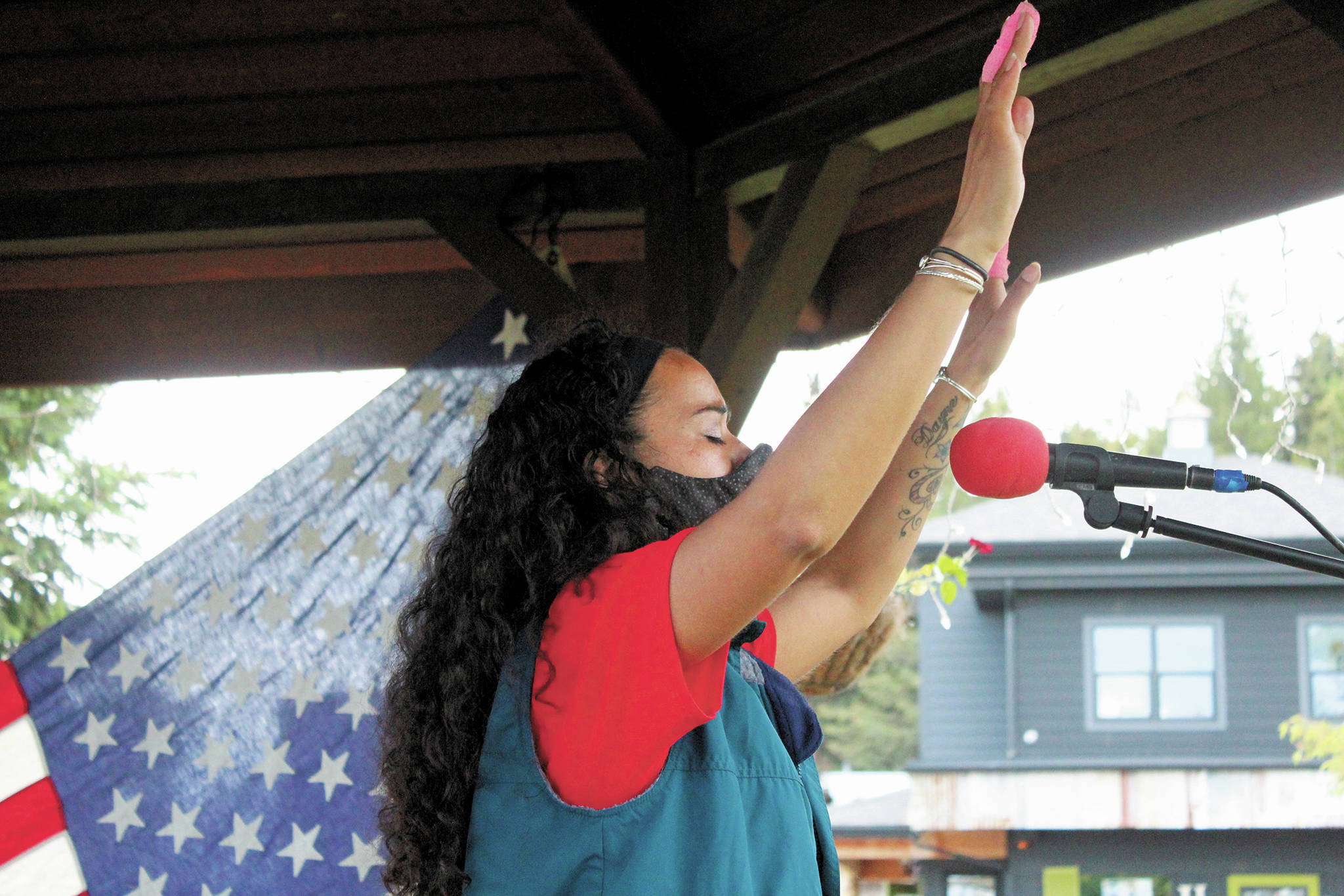 Winter Marshall-Allen, a local teacher and co-organizer of Homer’s first Juneteenth celebration, raises her hands while singing along to a faith song at the Friday, June 19, 2020 celebration at WKFL Park in Homer, Alaska. (Photo by Megan Pacer/Homer News)