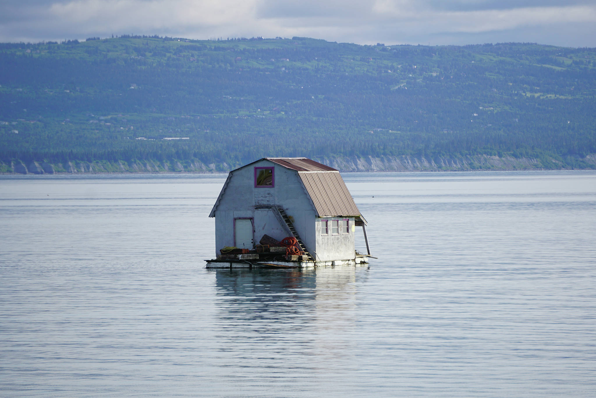 A float house is anchored in Mud Bay near the Nick Dudiak Fishing Lagoon on Monday, June 29, 2020, in Homer, Alaska. The house had been docked in Halibut Cove and was moved by its new owners over the weekend. Don Darnell said he built the float house about 40 years ago for fisherman Al Ray Carroll, who used it as a gear shed. (Photo by Michael Armstrong/Homer News)