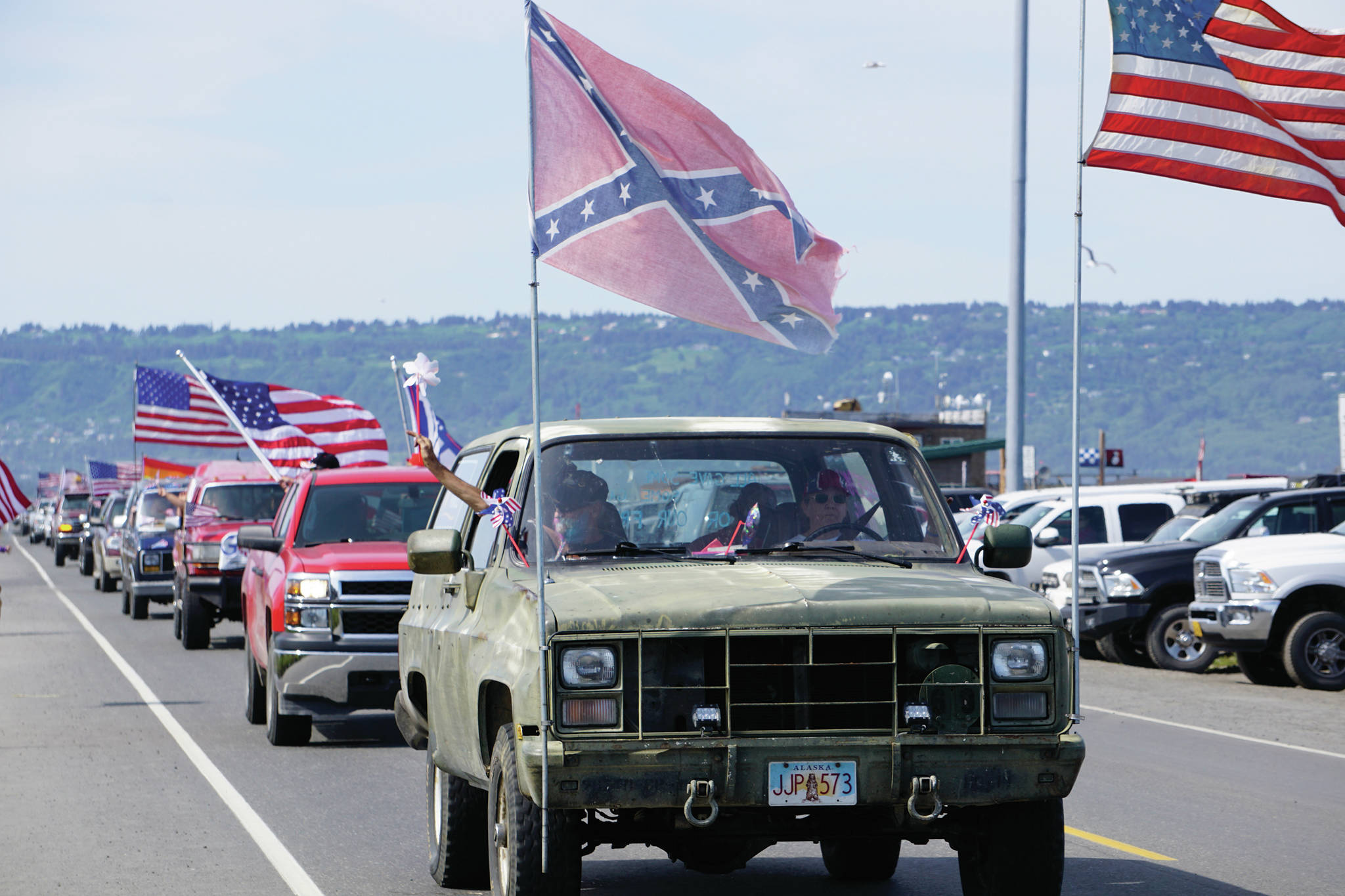 An unidentified man wearing a Confederate cap and flying a Confederate flag from his car participates in a July 4, 2020 parade that went from Soundview Avenue on the Sterling Highway to the end of the Homer Spit in Homer, Alaska. Some people view the flag as an expression of Southern heritage, while others see it as a symbol representing racism, white supremacy and the Civil War secessionists who fought to maintain slavery. (Photo by Michael Armstrong/Homer News)