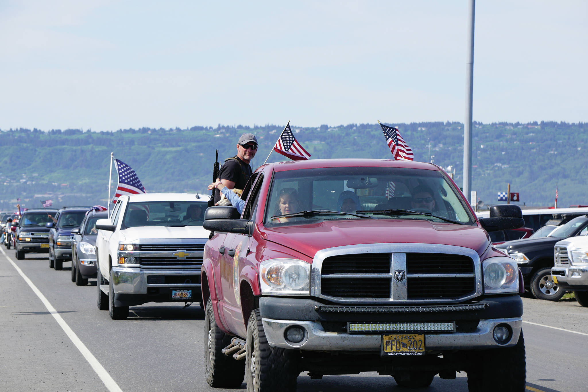 A man with an assault-style rifle rides in the back of a truck on Saturday, July 4, 2020, part of a community organized parade that went from Soundview Avenue on the Sterling Highway to the end of the Homer Spit in Homer, Alaska. (Photo by Michael Armstrong/Homer News)