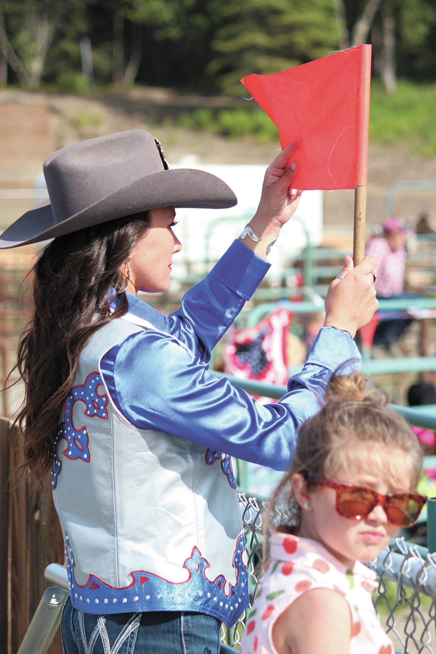 Kelsey Jo Konkright, Miss Rodeo Alaska 2020 of Anchorage, holds up a red flag, preparing to signal the start of an event, Saturday, July 4, 2020 during the Ninilchik Rodeo at the Kenai Peninsula Fairgrounds in Ninilchik, Alaska. (Photo by Megan Pacer/Homer News)