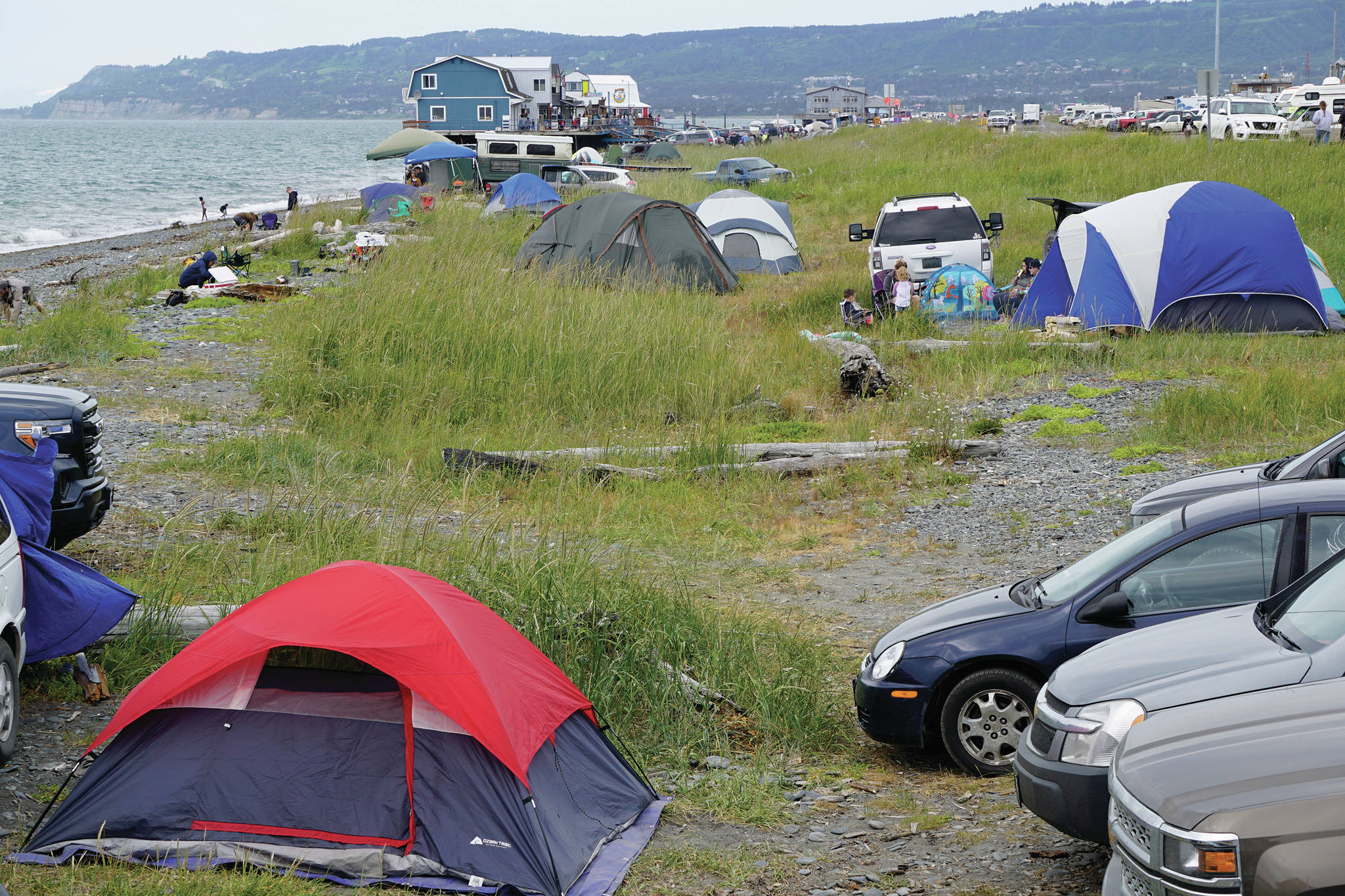 Visitors camp on Friday, July 3, 2020, on the Homer Spit in Homer, Alaska, in a vegetated area closed to camping between the Homer Shores Boardwalk, seen here in the background, and the Central Charters Boardwalk. (Photo by Michael Armstrong/Homer News)