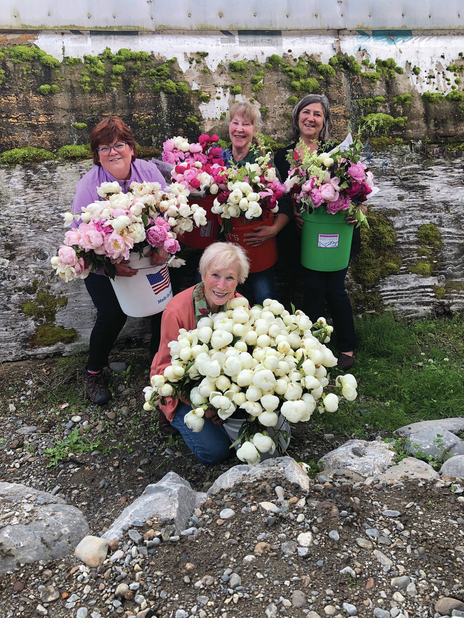 Teri Robl, at left, top, poses with friends on Aug. 7, 2020, at Alaska Perfect Peony in Fritz Creek, Alaska. From left to right, top, are Robl, Suzanne Singer-Alvarez and Sarah Jackinsky. At front is Rita Jo Shoultz, owner of Alaska Perfect Peony. (Photo by Julie Shaw)