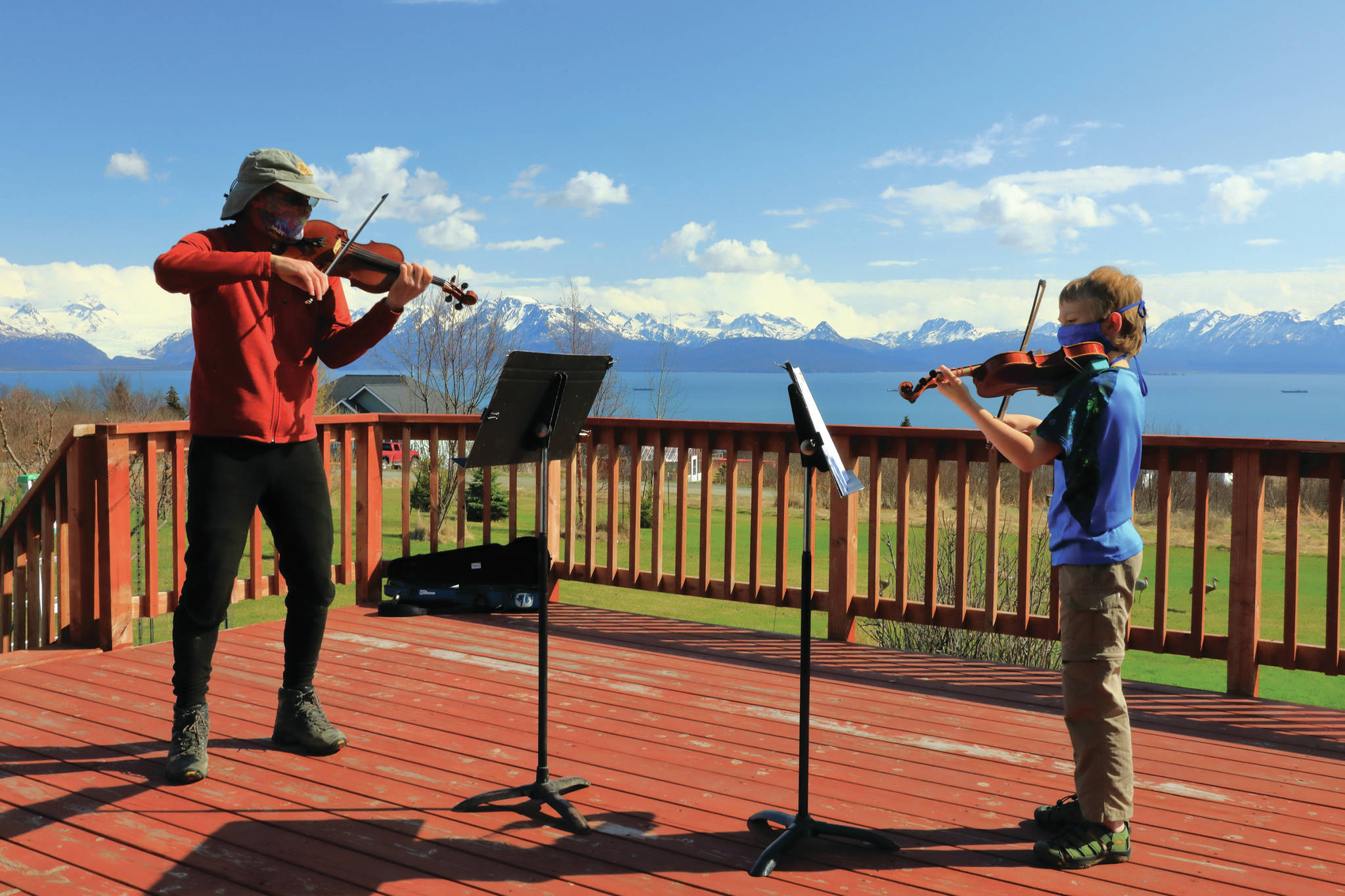 Violin instructor Daniel Perry, left, teaches student Daniel Christ, right, in an outdoor session on April 30, 2020, in Homer, Alaska. (Photo by Aaron Christ)
