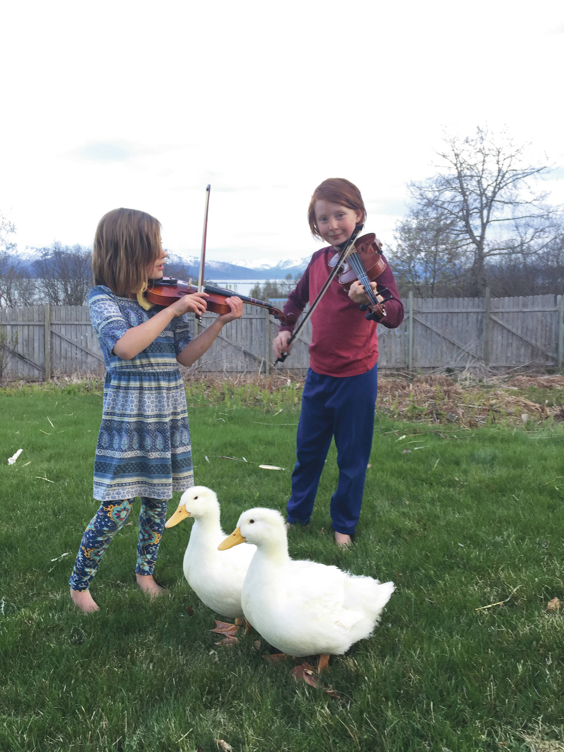 Sisters Ruby and Jazzy Gervais play for ducks on May 9, 2020, at their Homer, Alaska, home. (Photo courtesy OPUS)