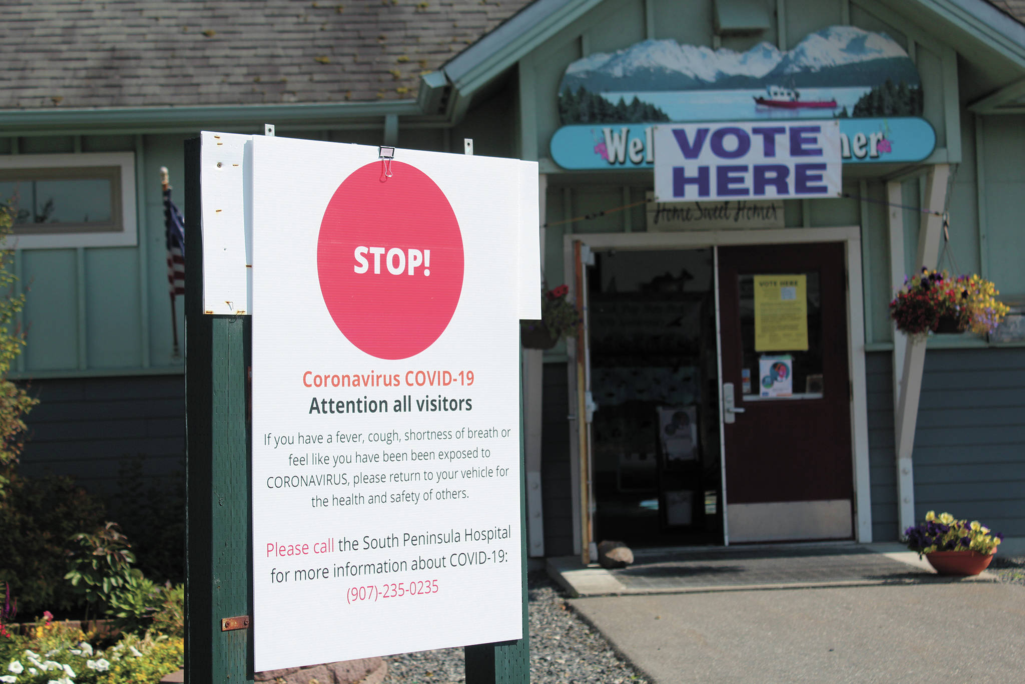 A sign outside the Homer Chamber of Commerce and Visitor Center warns voters about COVID-19 precautions being taken during the Primary Election on Tuesday, Aug. 18, 2020 in Homer, Alaska. (Photo by Megan Pacer/Homer News)