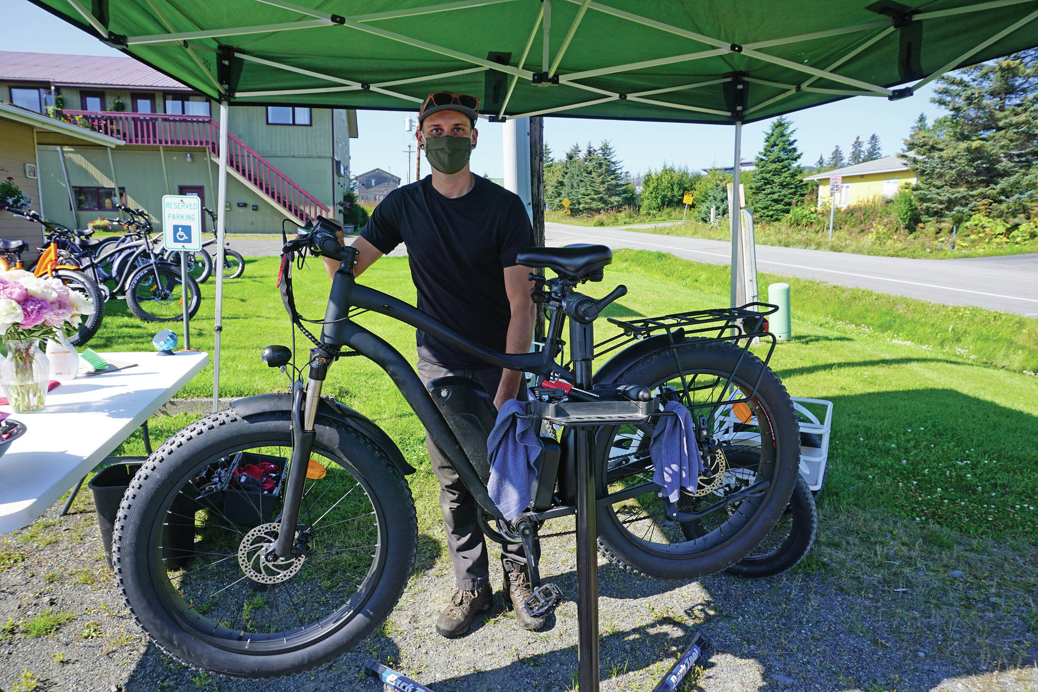 Chase Warren, the bike mechanic for LoopEride, displays some of the electric-motor assist bicycles at an open house held Friday, Aug. 21, 2020, at the company’s showroom on East Bunnell Avenue in Homer, Alaska. (Photo by Michael Armstrong/Homer News)