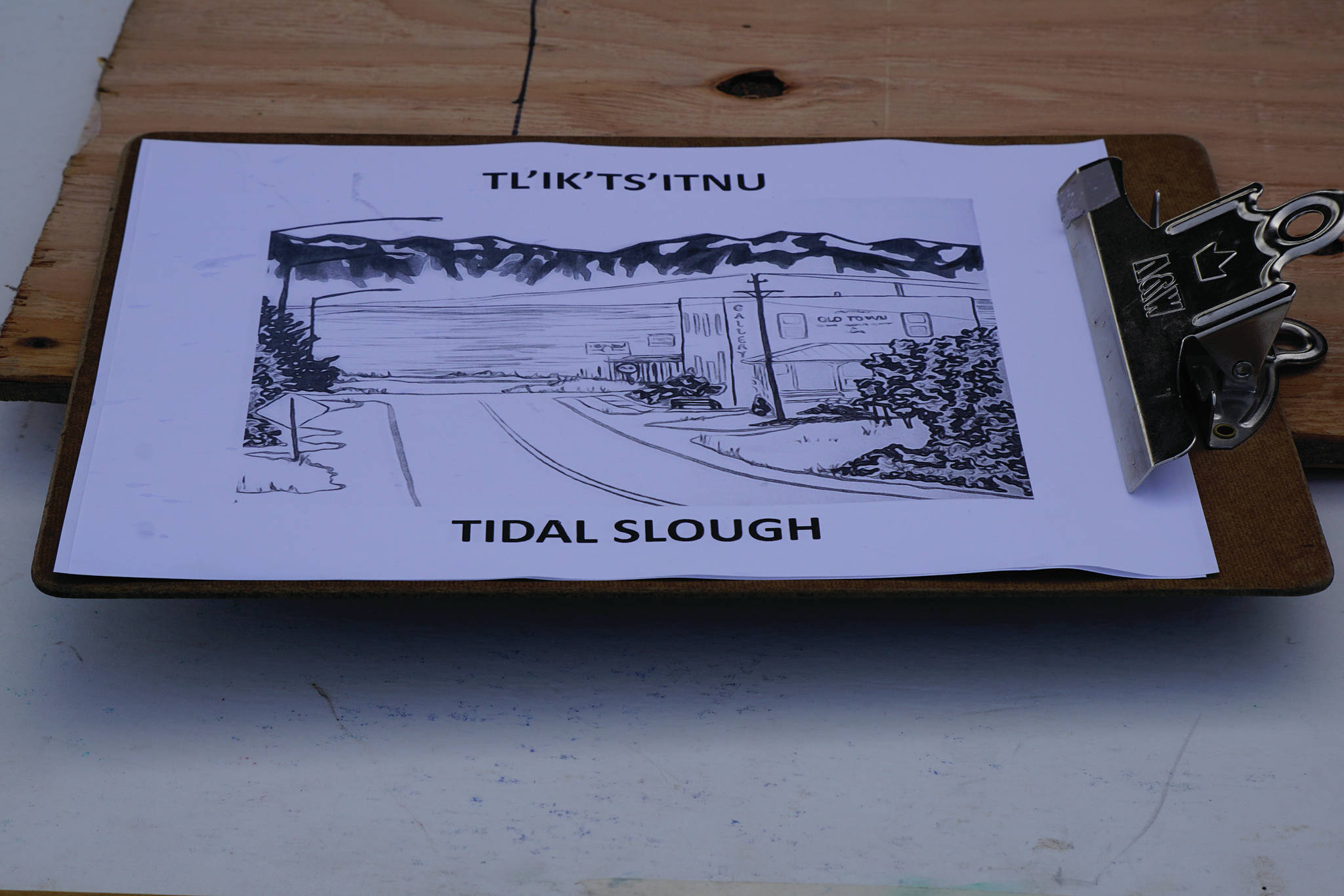 A clipboard shows the Dena’ina word for “tidal slough,” “Tl’ik’ts’itnu” with an illustration of the Old Town area of Homer. It was part of the material used in “Land Acknowledgement in Action: Sign Installation” last Saturday, Aug. 22, 2020, at the Bishop’s Beach pavillion — the area known by the Dena’ina people as “Tuggeht,” or “at the water.” (Photo by Michael Armstrong/Homer News.)