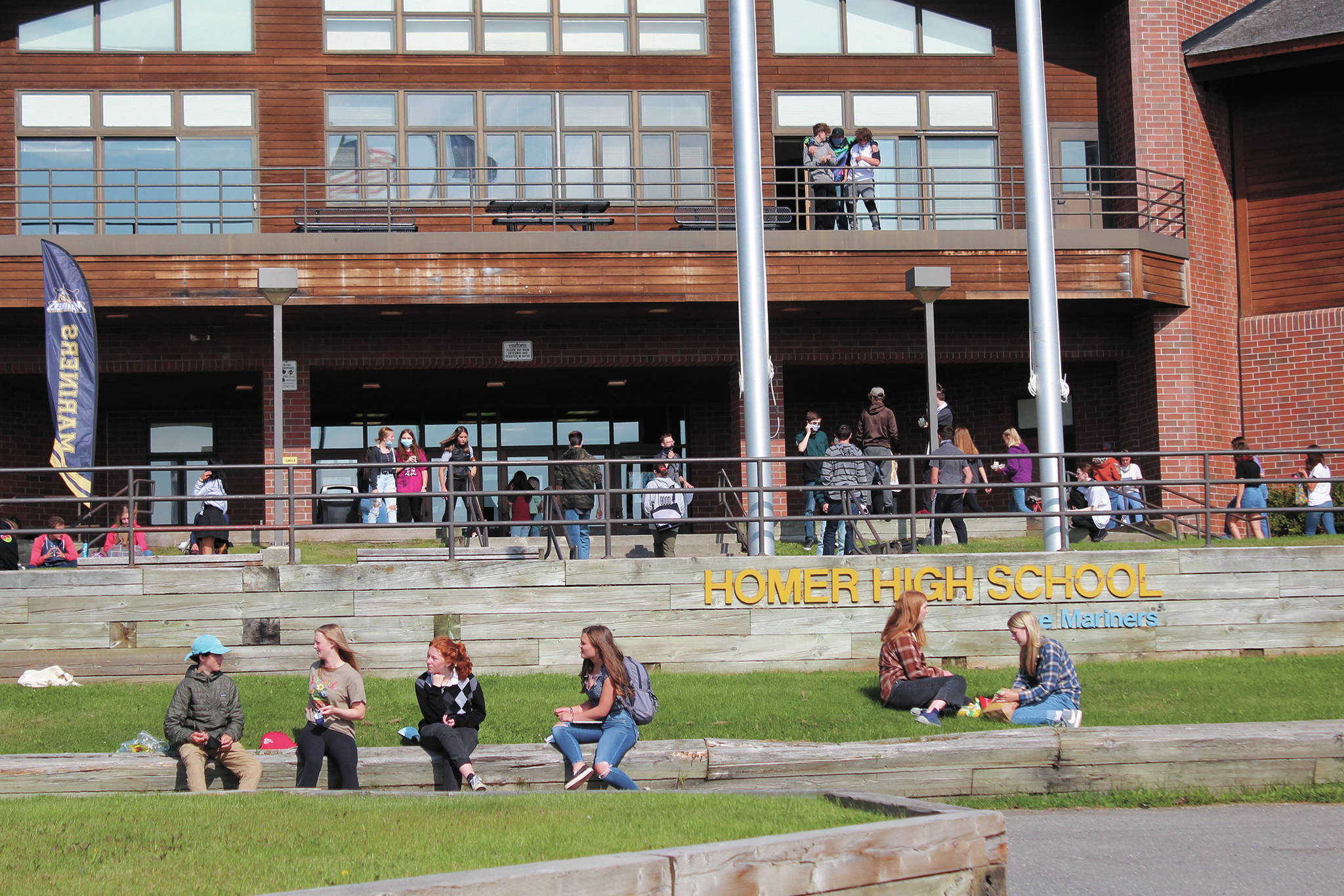 Homer High School students finish eating lunch outside the school while others make their way back into the building for the next class period on Monday, Aug. 24, 2020 in Homer, Alaska. (Photo by Megan Pacer/Homer News)