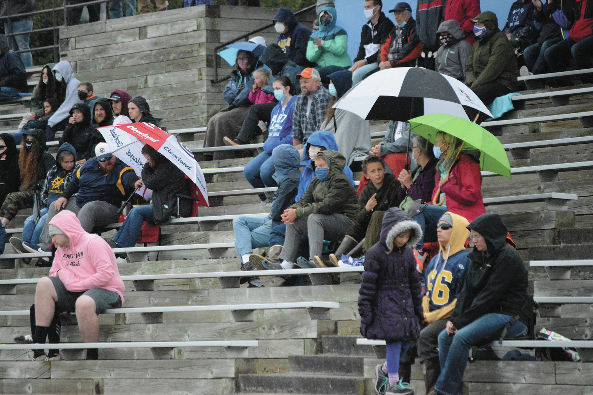 Mariner fans — some wearing masks and social distancing — endure a heavy rain at a Saturday, Aug. 29, 2020 football game against Seward High School in Homer, Alaska. (Photo by Michael Armstrong/Homer News)