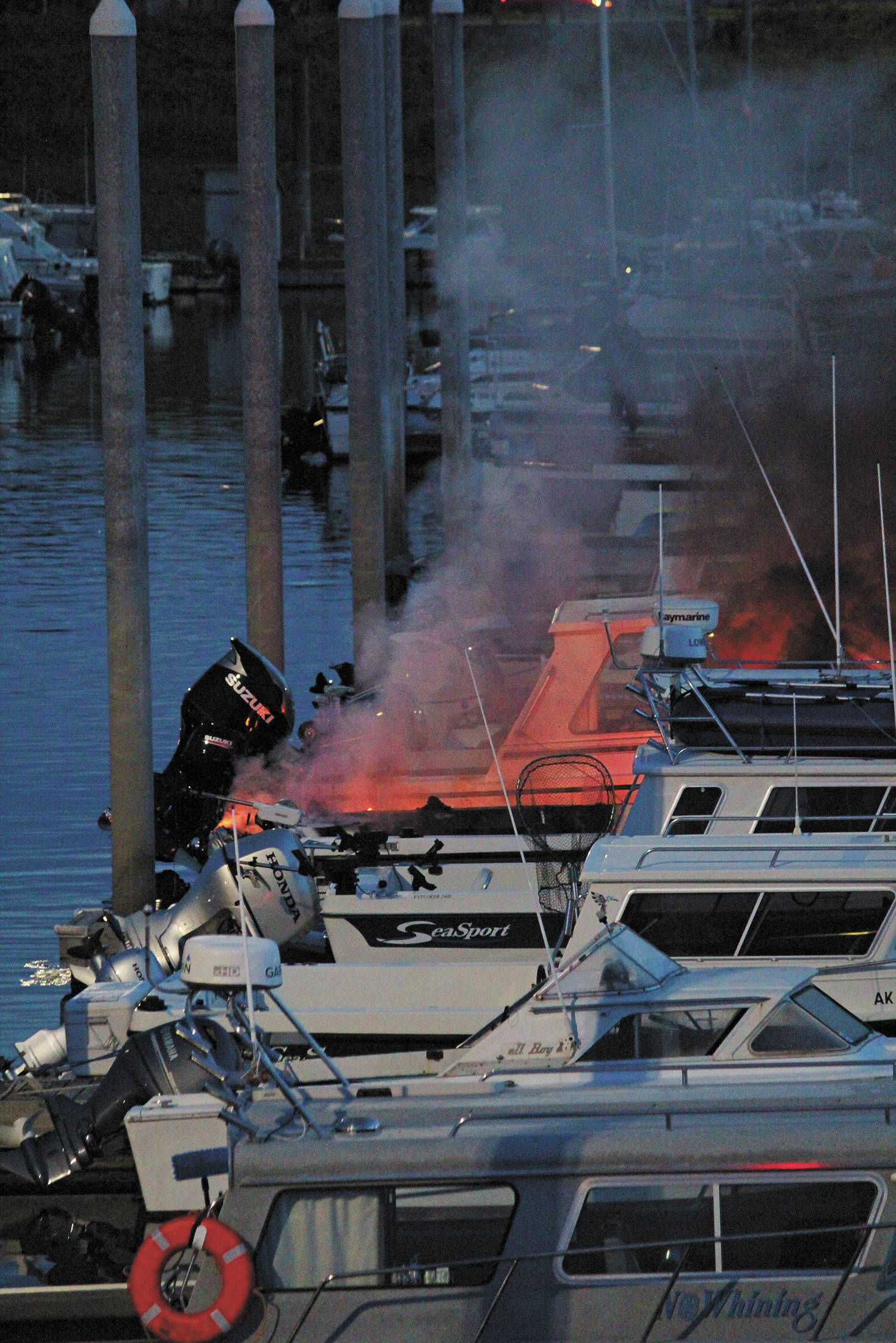 Flames and smoke rise from a 32-foot fiberglass boat docked in the Homer Harbor on the evening of Friday, Sept. 11, 2020 in Homer, Alaska. No one was harmed and the Homer Volunteer Fire Department put out the fire. (Photo by Megan Pacer/Homer News)