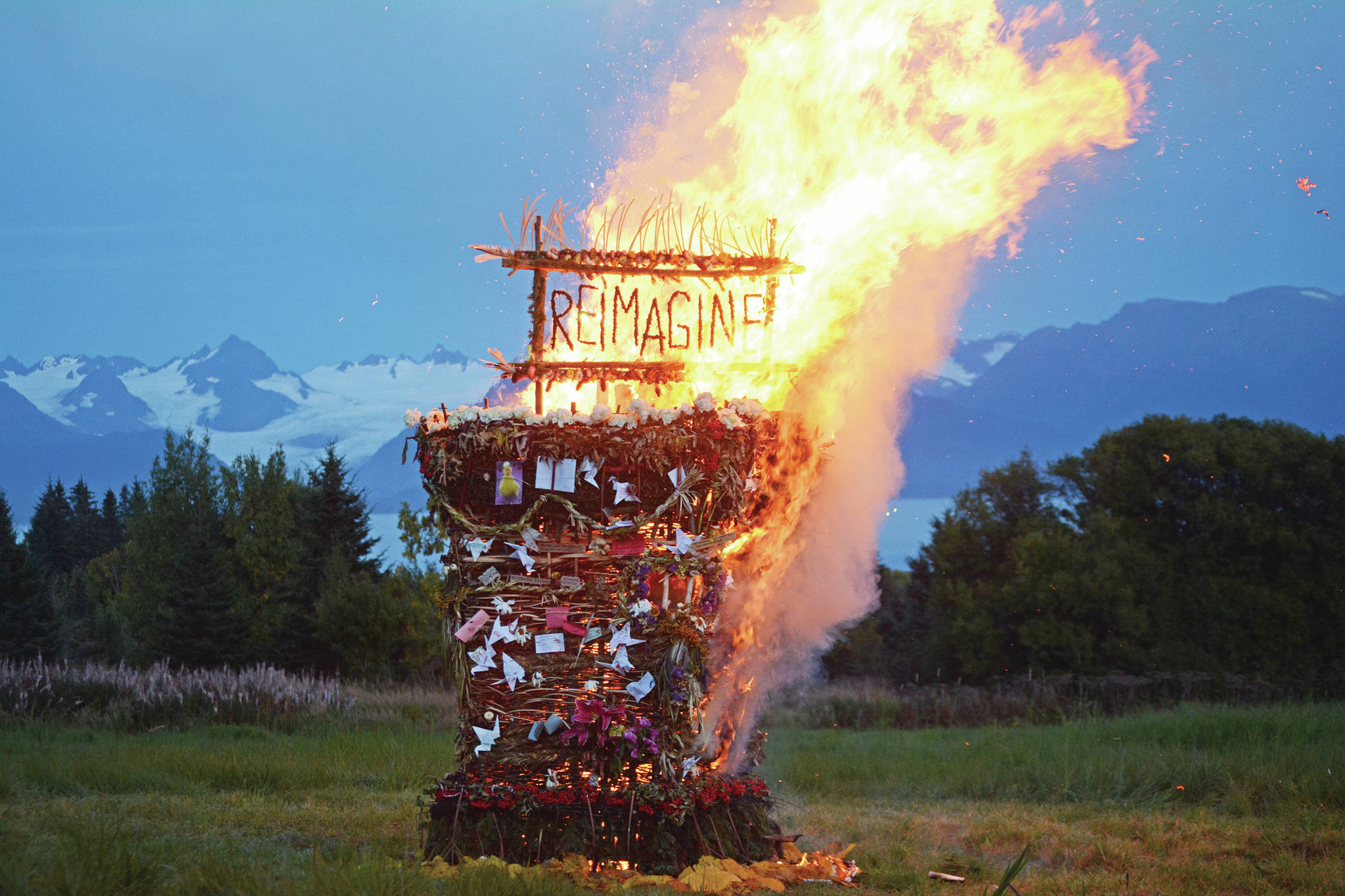 “Reimagine,” the 17th annual Burning Basket, catches fire in a field on Sunday, Sept. 13, 2020, near Homer, Alaska. Artist Mavis Muller intended to broadcast live on Facebook and YouTube the burning of the basket, but because of technical difficulties that didn’t happen. “Burning Basket teaches how to let go of expectations and accept the present moment,” Muller wrote in a text message. “Technology is fickle. The basket, however, did exactly what it promised to do. It helod our collective burderns, our memorials, our joys, sadness, fear, and dispersed all of our good intentions in a plume of smoke, sparks and flames.” (Photo by Michael Armstrong/Homer News)
