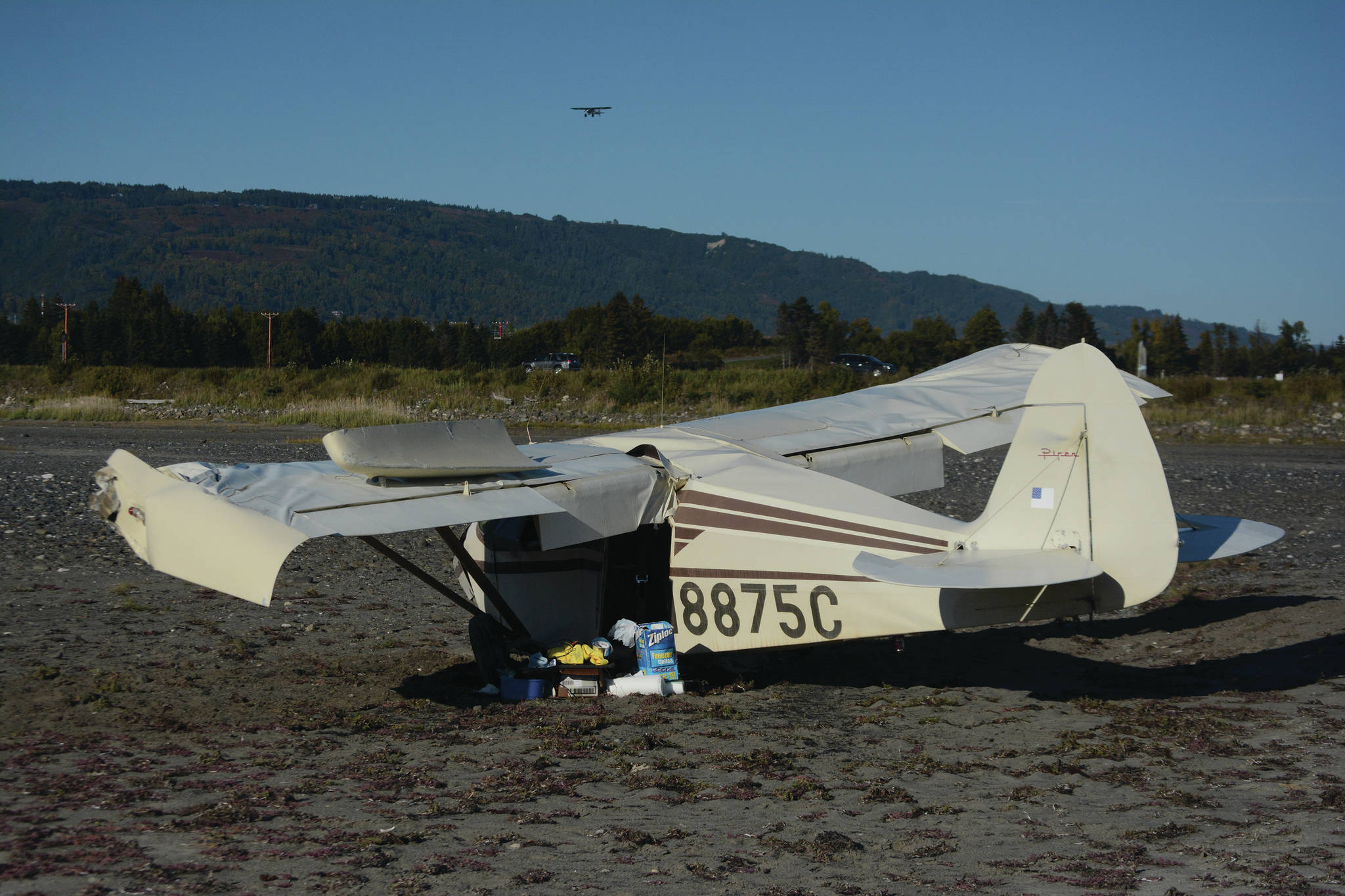 A crashed Piper 22-135 single-engine airplane lies on the mud flats of Mariner Park Slough at about 5:30 p.m. Sunday, Sept. 13, 2020, after it crashed about 45 minutes earlier on takeoff near the Homer, Alaska, Airport. The pilot and only person on board suffered minor injuries. (PHoto by Michael Armstrong/Homer News)