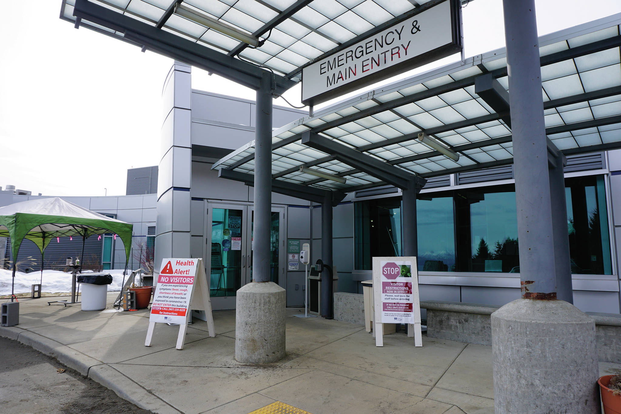 Signs on Saturday, March 28, 2020, at the main entrance to South Peninsula Hospital in Homer, Alaska, warn visitors not to enter until they have been met by hospital staff. (Photo by Michael Armstrong/Homer News)