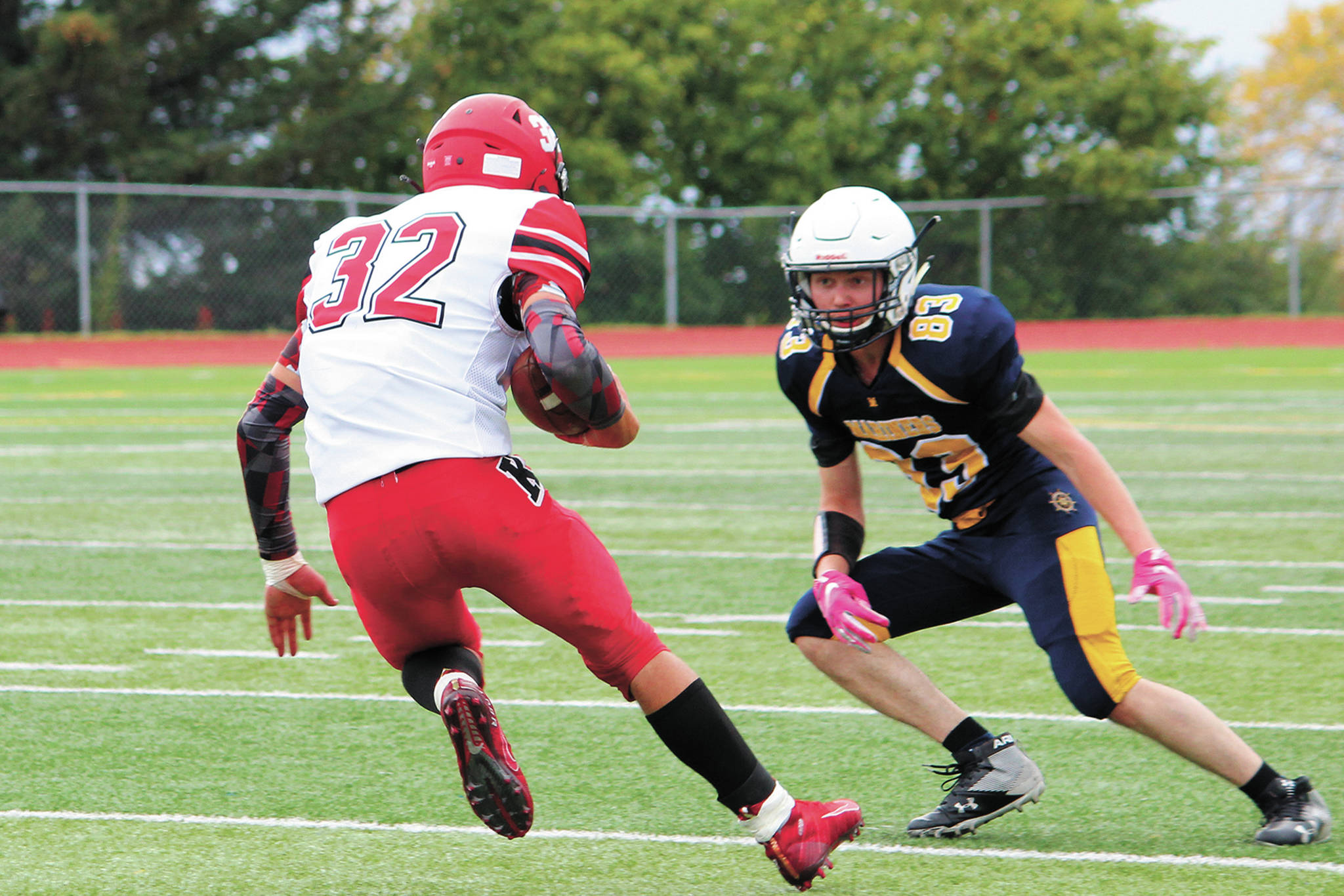 Kenai running back Tucker Vann looks to take the ball around Homer’s Markian Reutov during a Saturday, Sept. 19, 2020 football game at Homer High School in Homer, Alaska. The Mariners defeated the Kardinals 44-6. (Photo by Megan Pacer/Homer News)