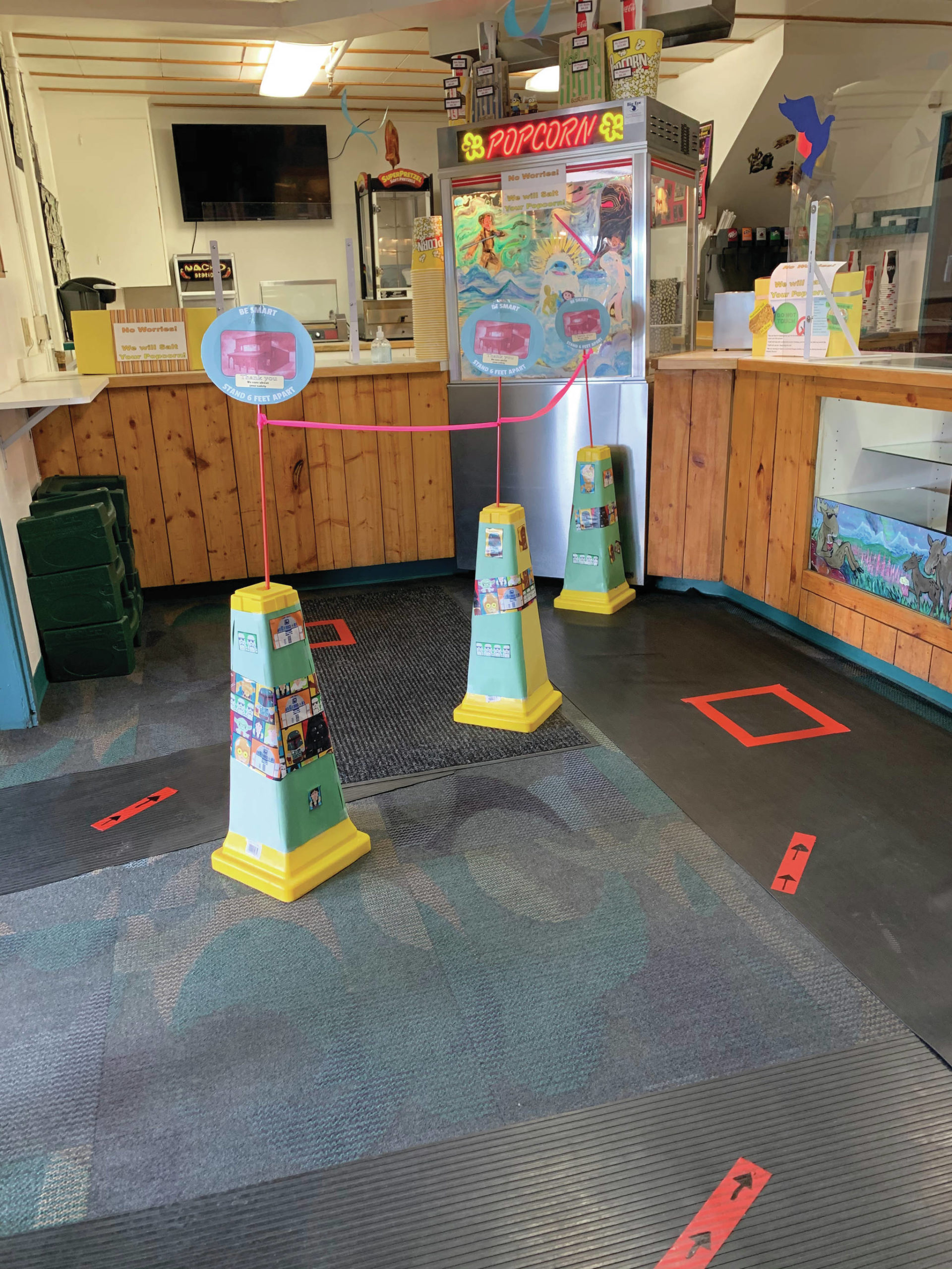Modifications to the Homer Theatre lobby including 6-foot distancing marks and plastic shields at the concession counter, as seen here in this photo taken Sept. 14, 2020, at the movie theater in Homer, Alaska. (Photo courtesy of Homer Theatre)