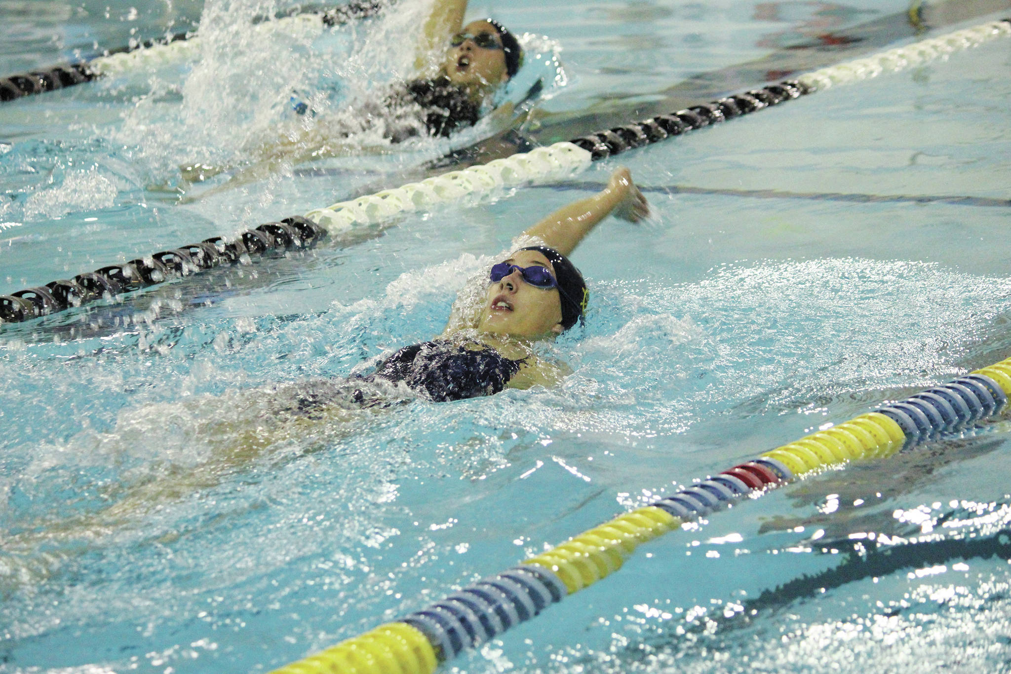 Homer’s Delta Fabich and Madison Story (upper left) compete in the girls 100 yard backstroke Friday, Oct. 2, 2020 during a dual meet against Seward High School at the Kate Kuhns Aquatic Center in Homer, Alaska. (Photo by Megan Pacer/Homer News)