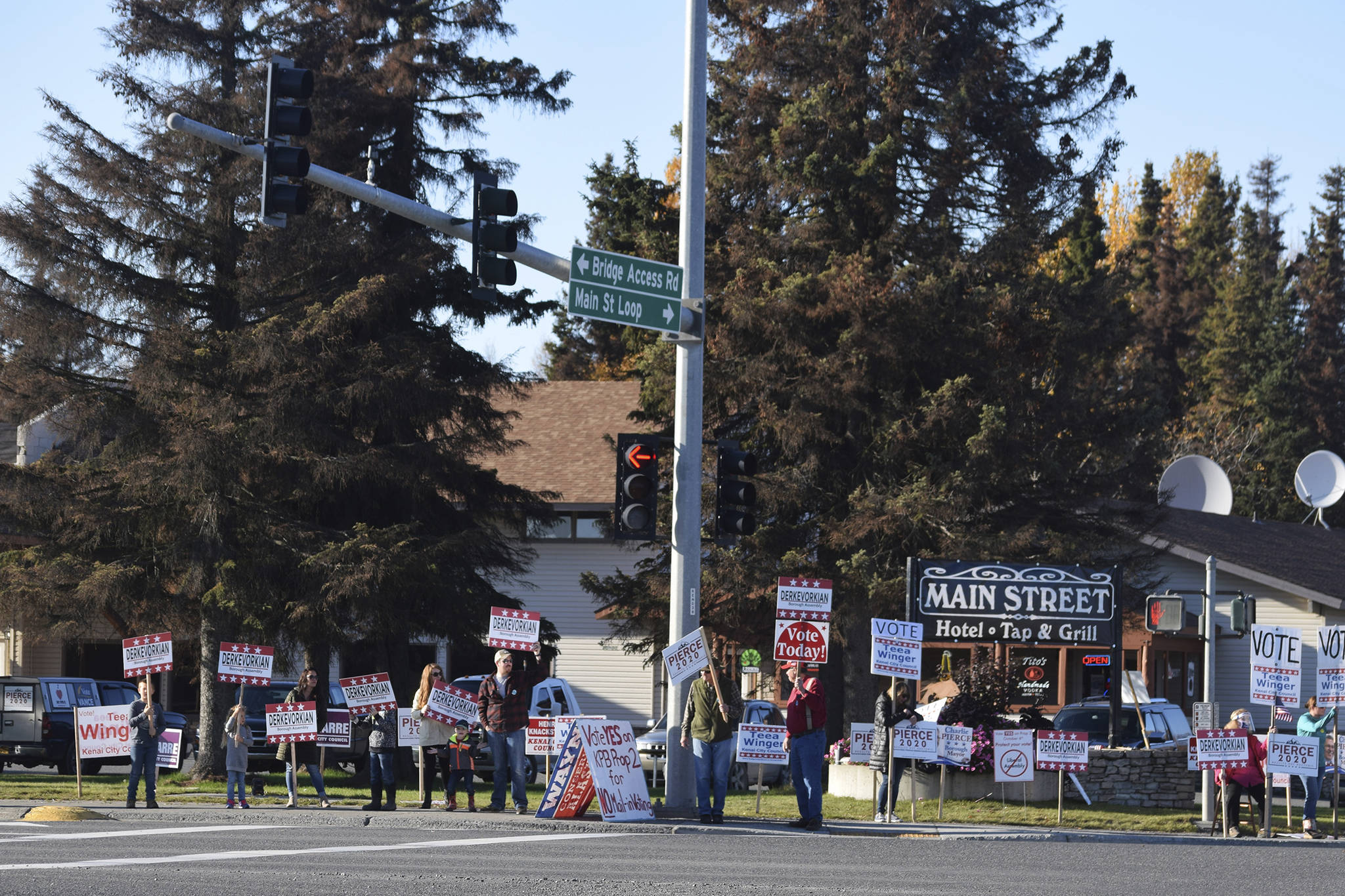 People hold signs at the intersection of Main Street Loop and Kenai Spur Highway on Tuesday, Oct. 6, 2020 in Kenai, Alaska. (Photo by Ashlyn O'Hara/Peninsula Clarion)