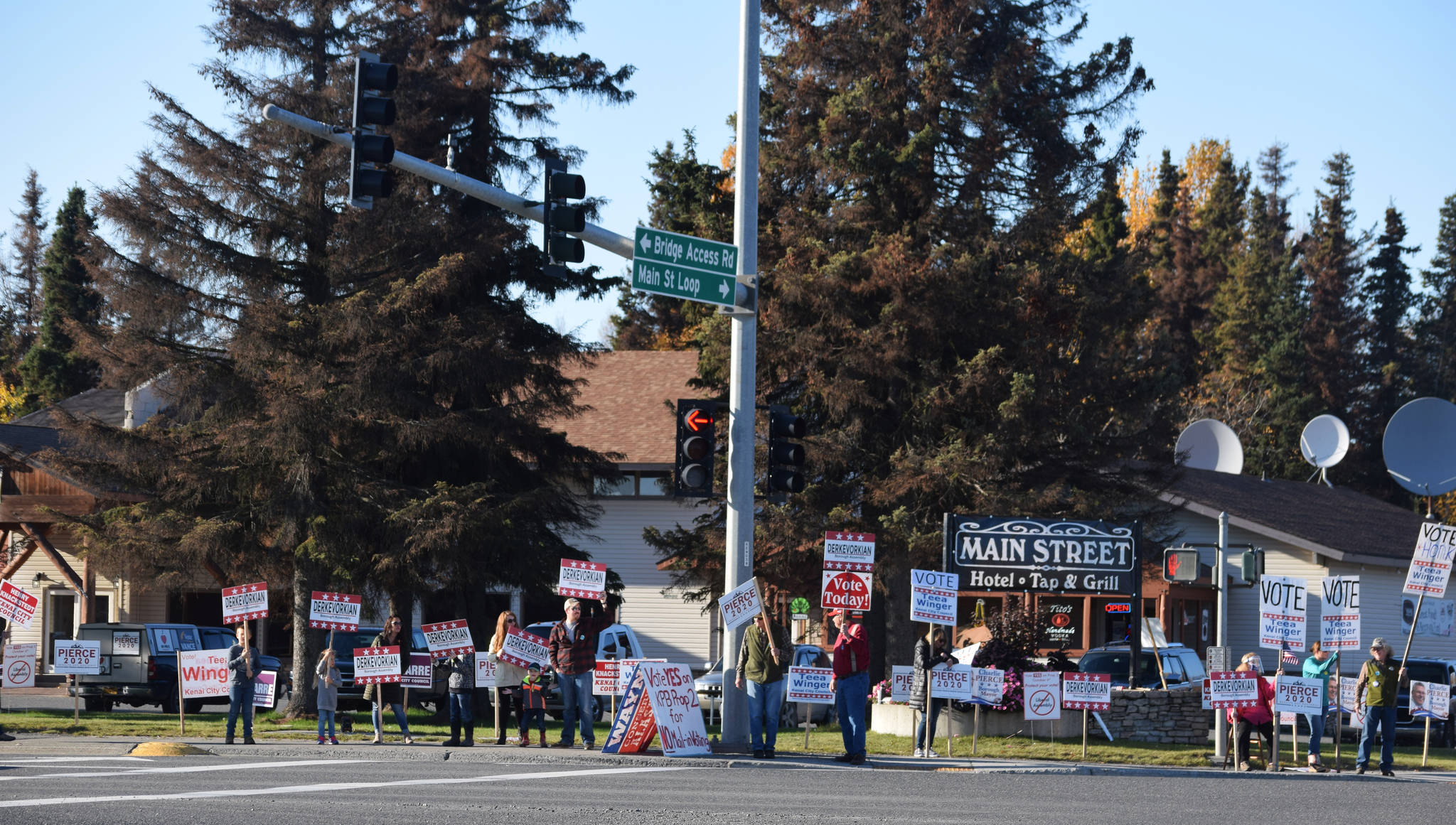 People hold signs at the intersection of Main Street Loop and Kenai Spur Highway on Tuesday, Oct. 6, 2020 in Kenai, Alaska. (Photo by Ashlyn O’Hara/Peninsula Clarion)