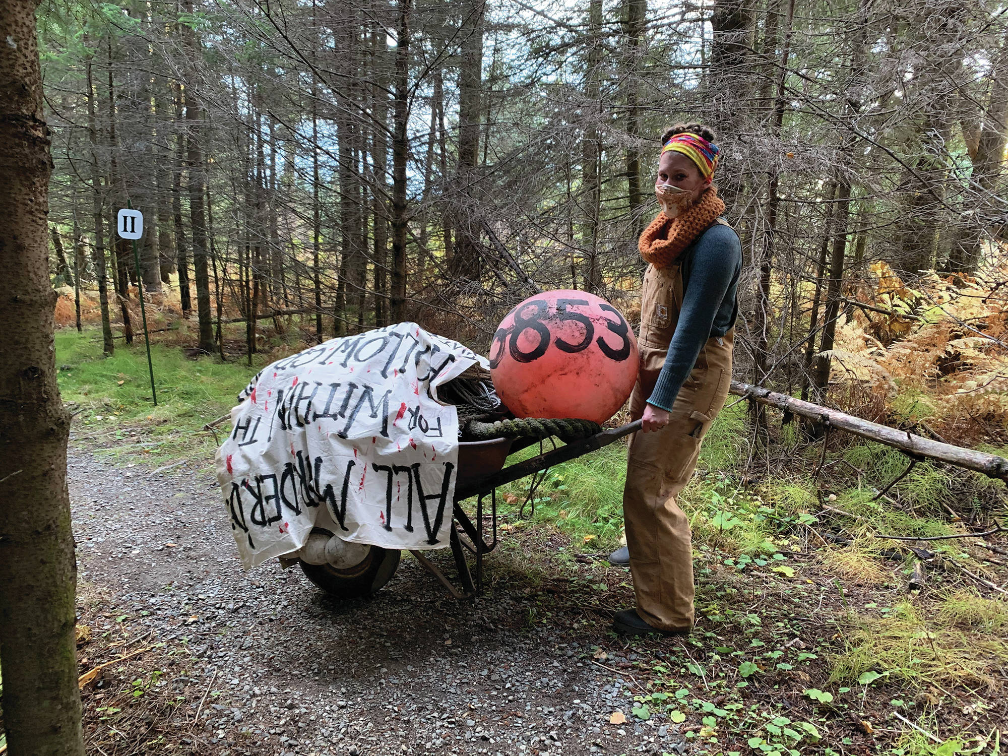 Sarah Brewer moves some props for “Haunted Shakespeare” in a photo taken Oct. 12, 2020, at the Pratt Museum forest trail in Homer, Alaska. Brewer is the curator and director of the evening of theater. (Photo courtesy Pier One Theatre)
