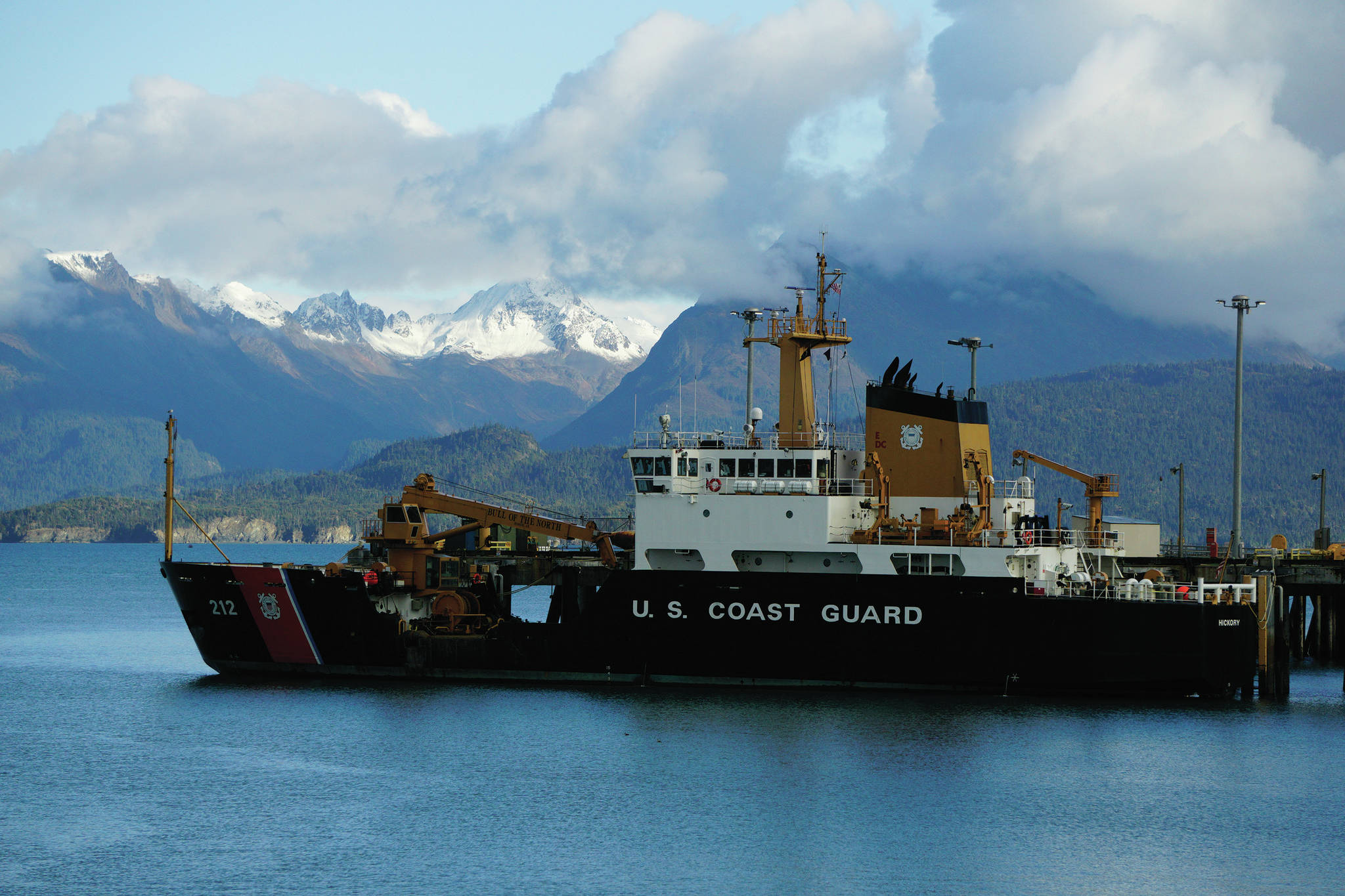 The U.S. Coast Guard Cutter Hickory is moored on Oct. 10, 2020, at the Pioneer Dock in Homer, Alaska. Fresh snow or termination dust covers the peaks of the Kenai Mountains across Kachemak Bay, a sign of the coming winter. (Photo by Michael Armstrong/Homer News)